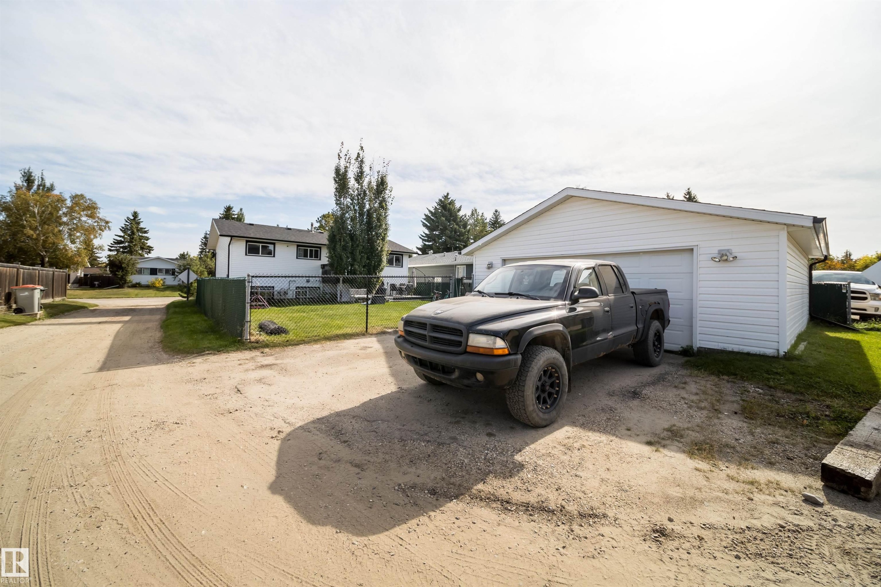 Detached garage with white siding and a gravel driveway - 4104 44 Street, Stony Plain, AB