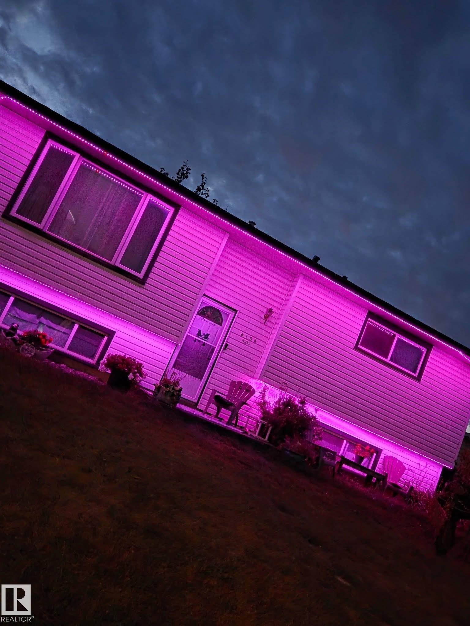 Siding exterior featuring multiple windows and a front entry door - 4104 44 Street, Stony Plain, AB