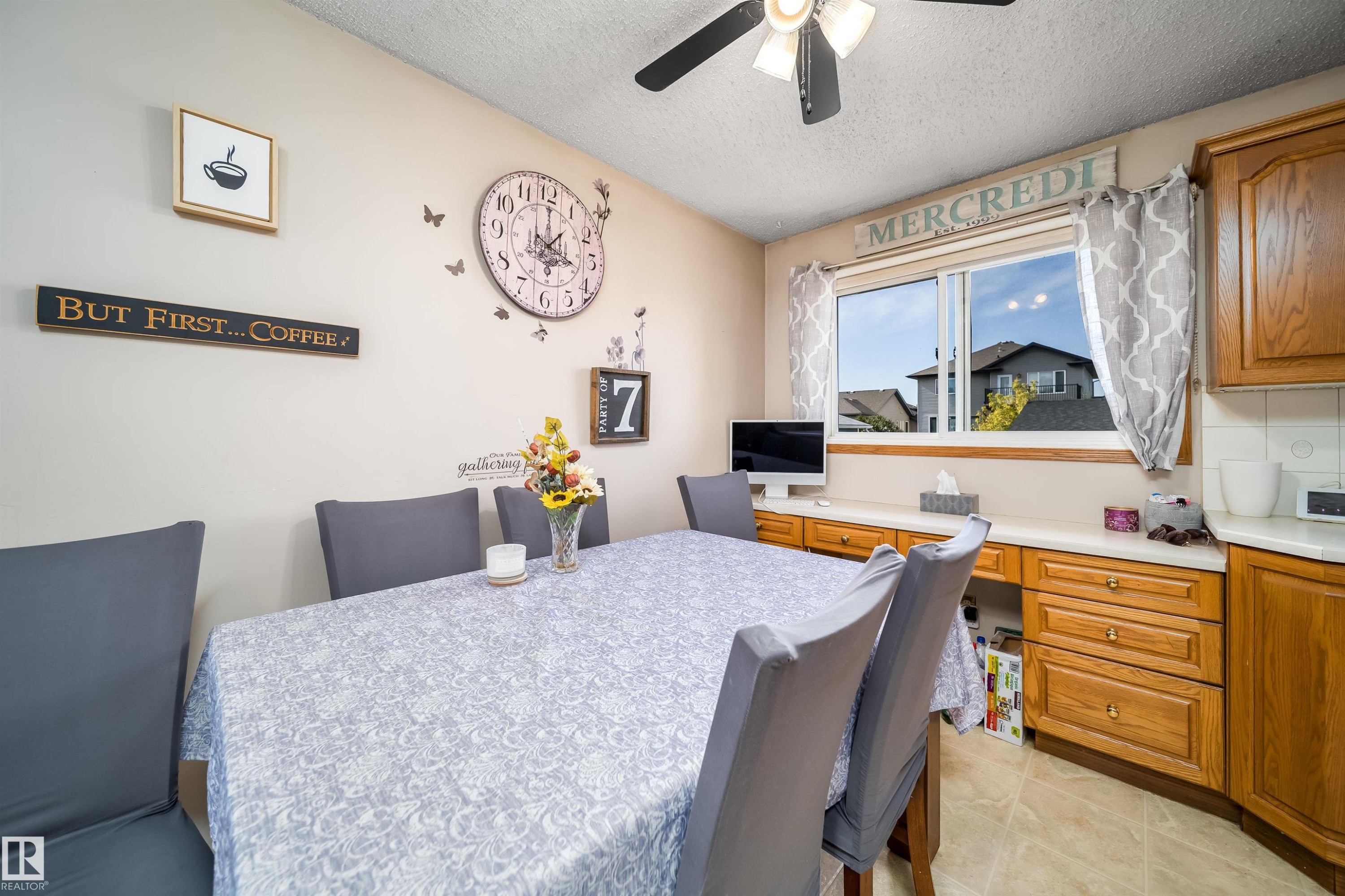 Built-in desk area with wood cabinetry and light-toned countertop, accompanied by a window with a white frame - 4104 44 Street, Stony Plain, AB