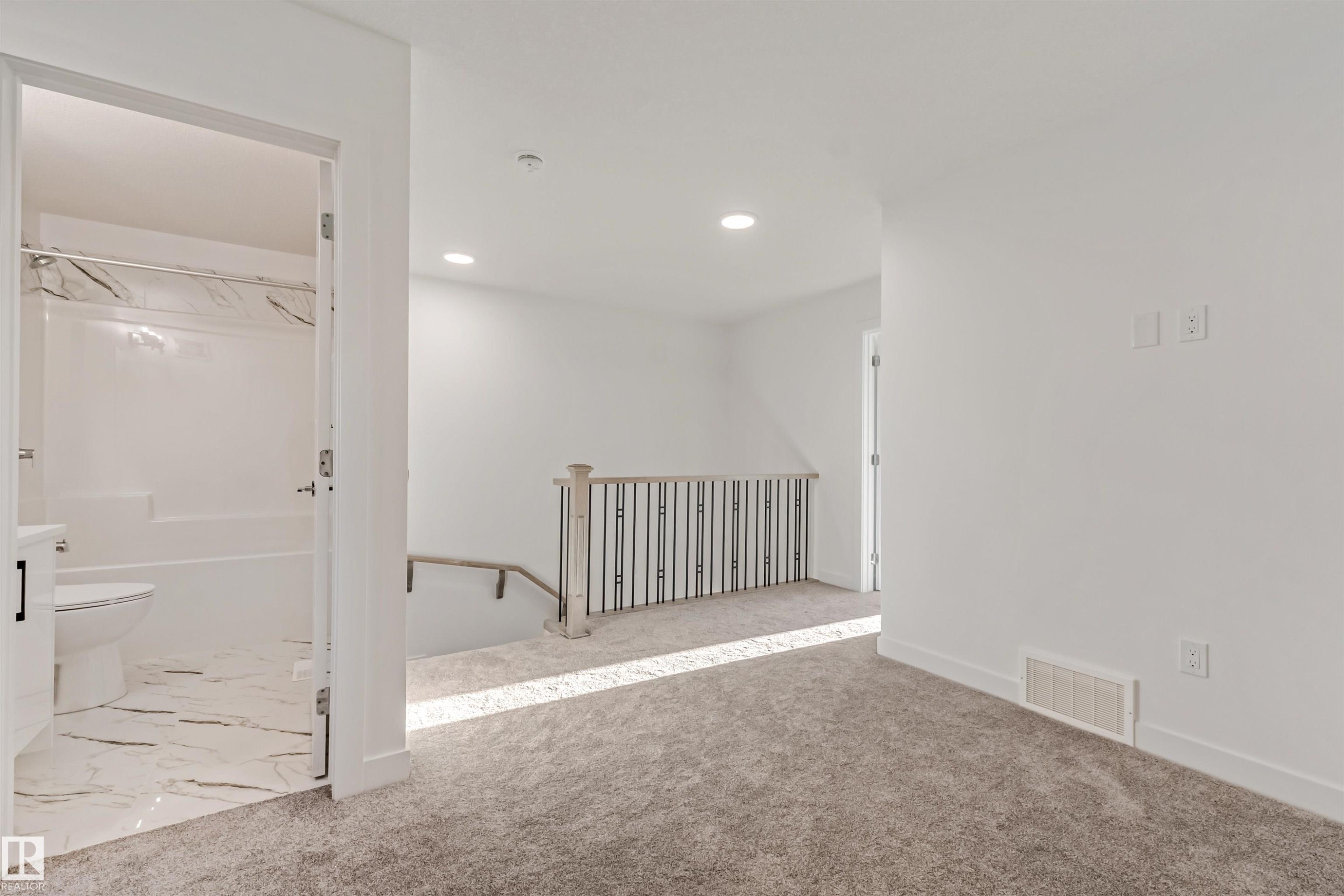 Plush carpeting, recessed lighting, and a modern stair railing with black spindles - 1515 211 Street Nw, Edmonton, AB