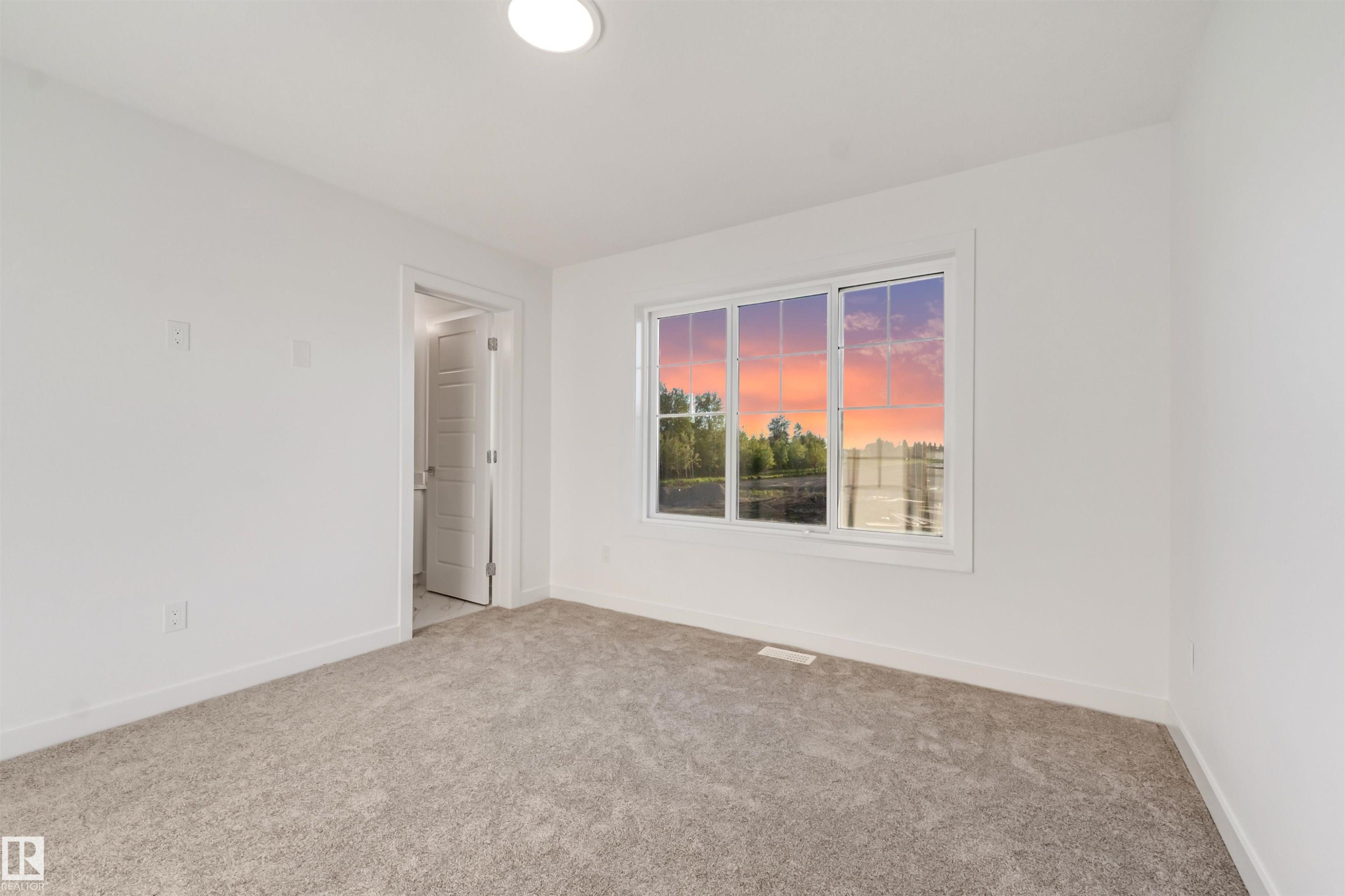 Recessed ceiling lighting, broad window, soft carpeting, white baseboards, and a white interior door - 1515 211 Street Nw, Edmonton, AB