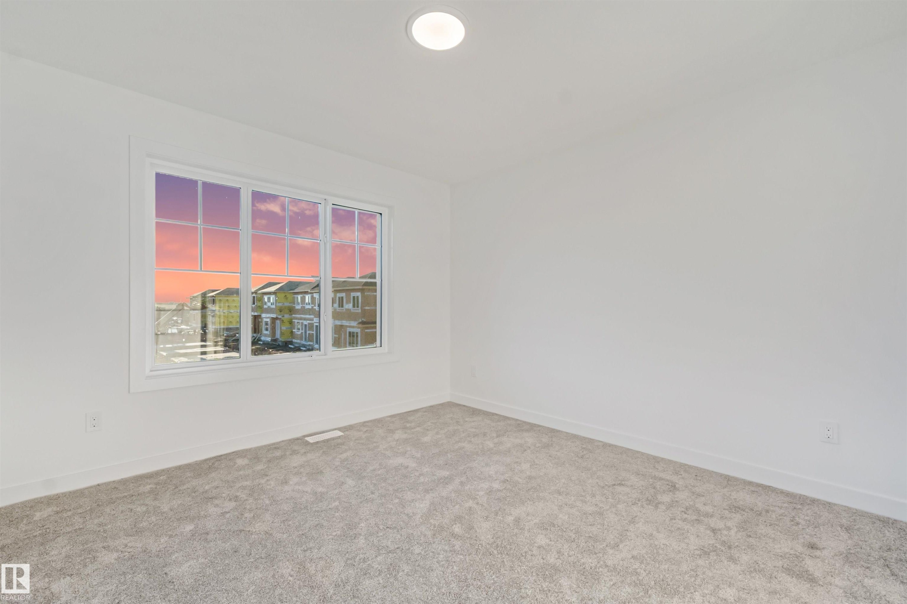 Recessed ceiling light, white walls, light gray carpet, and large window with white framing - 1515 211 Street Nw, Edmonton, AB