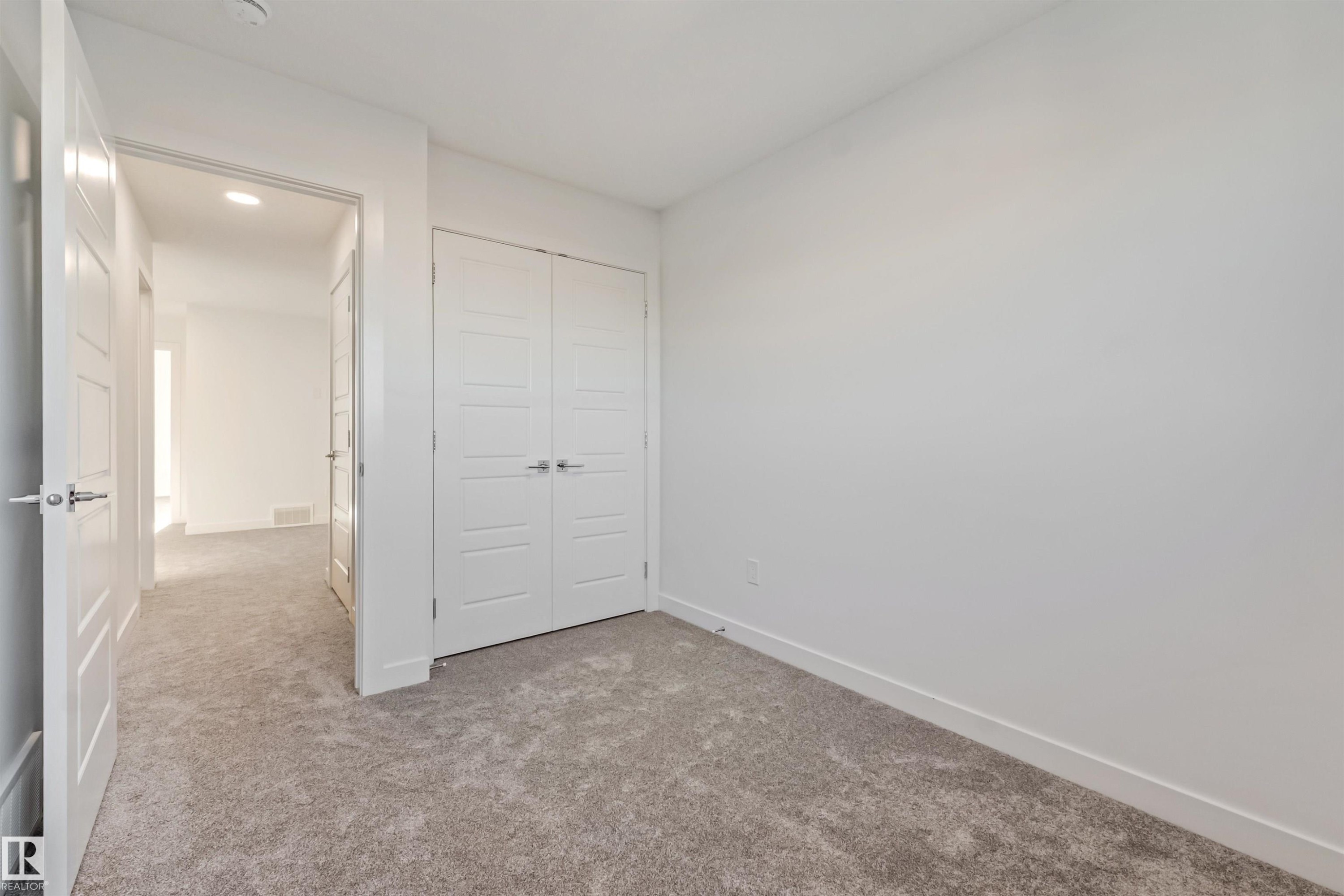 Soft gray carpeting and a double-door closet with modern hardware - 1515 211 Street Nw, Edmonton, AB