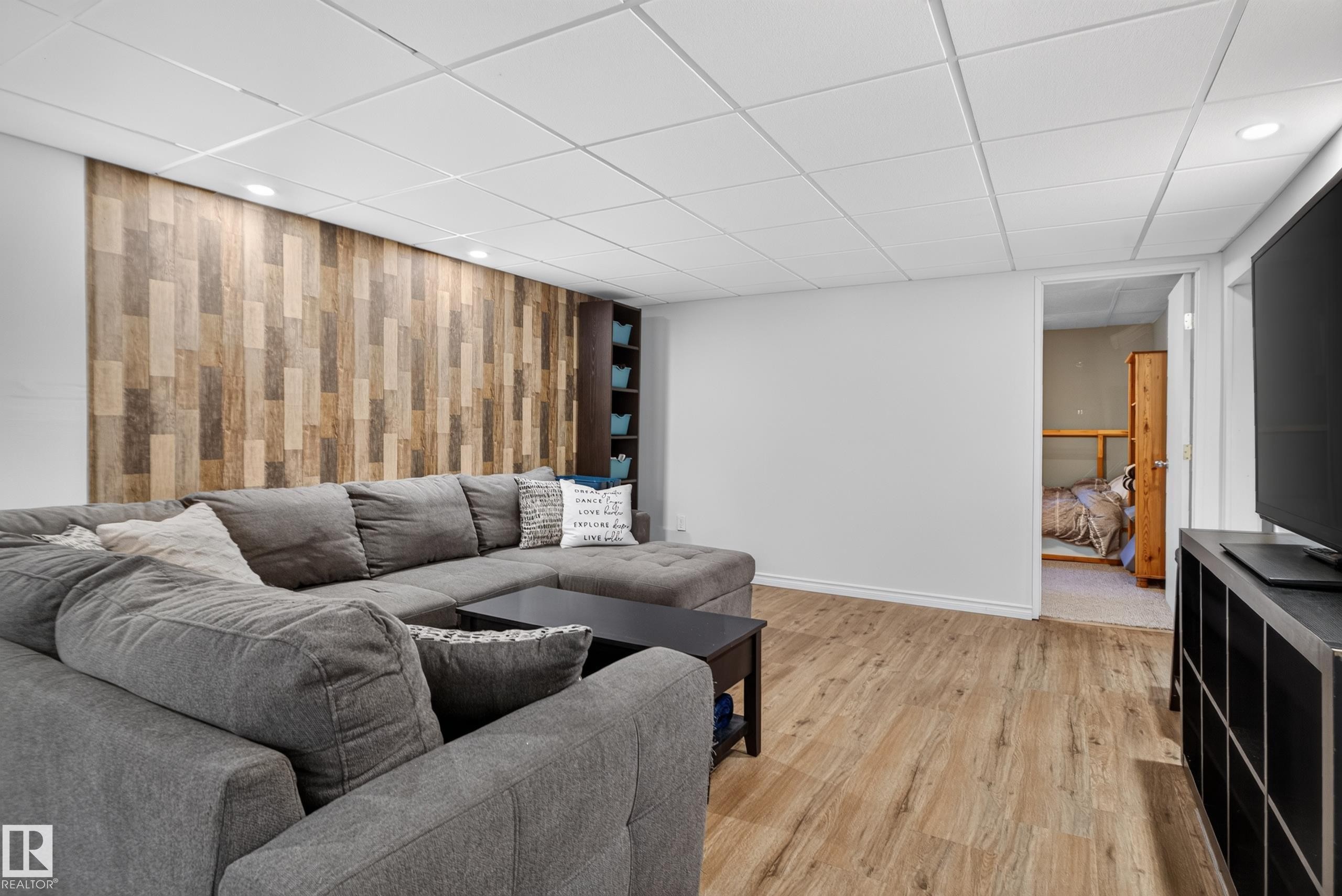 Wood-finish flooring with recessed lighting, a decorative wood plank accent wall, and built-in shelving - 14611 109 Avenue Nw, Edmonton, AB