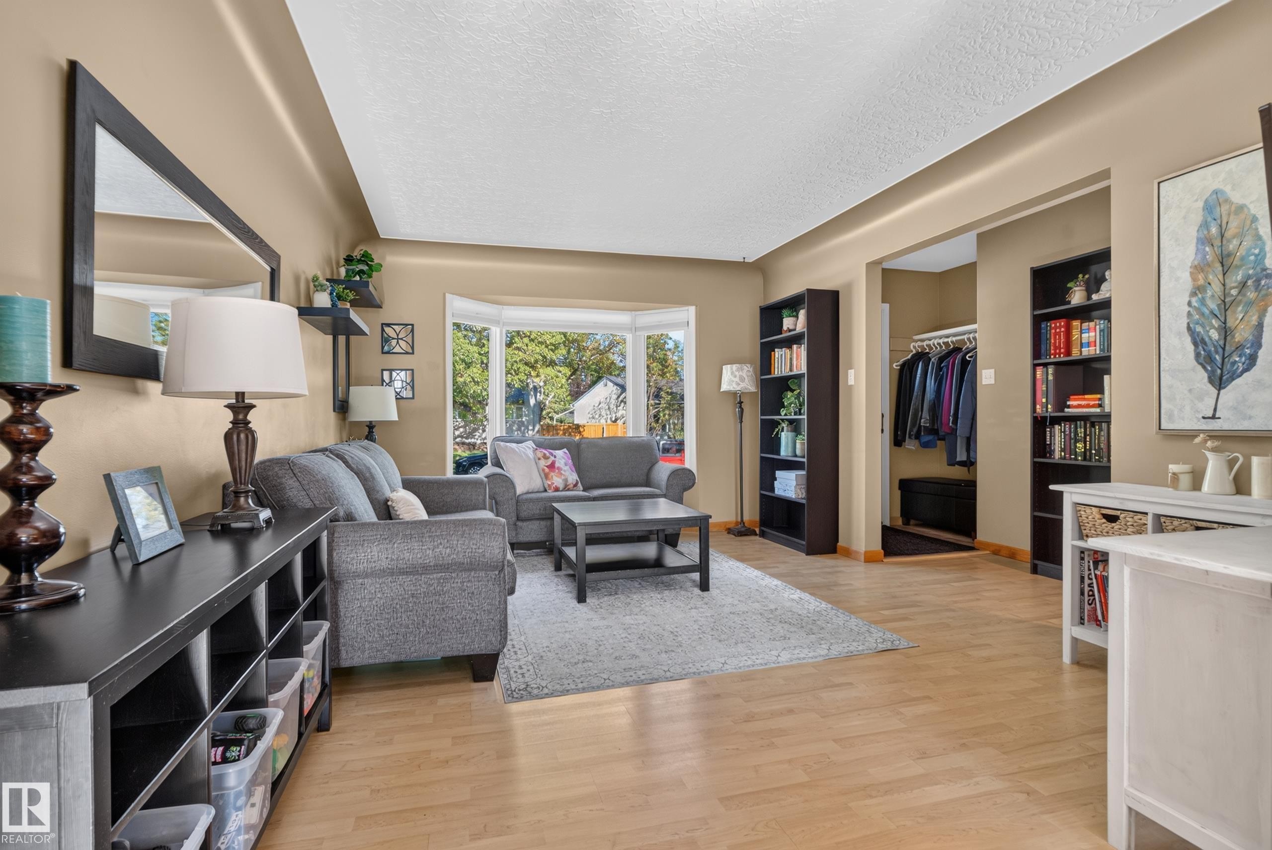 Wood-finish flooring throughout, featuring a bay window, recessed entryway, and built-in shelving - 14611 109 Avenue Nw, Edmonton, AB