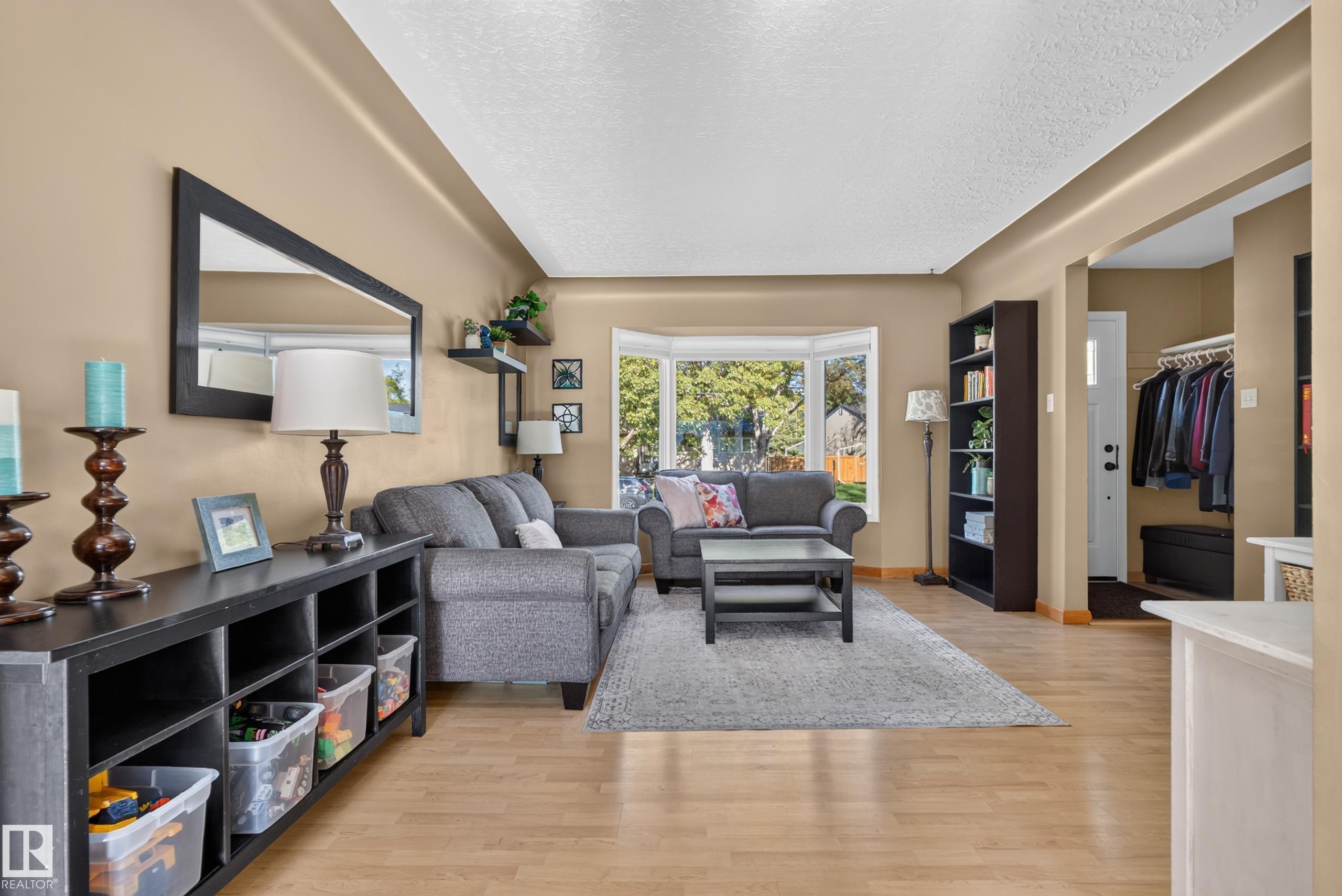 Bay window, wood-finish flooring, built-in shelving, front entry closet, and arched doorway - 14611 109 Avenue Nw, Edmonton, AB