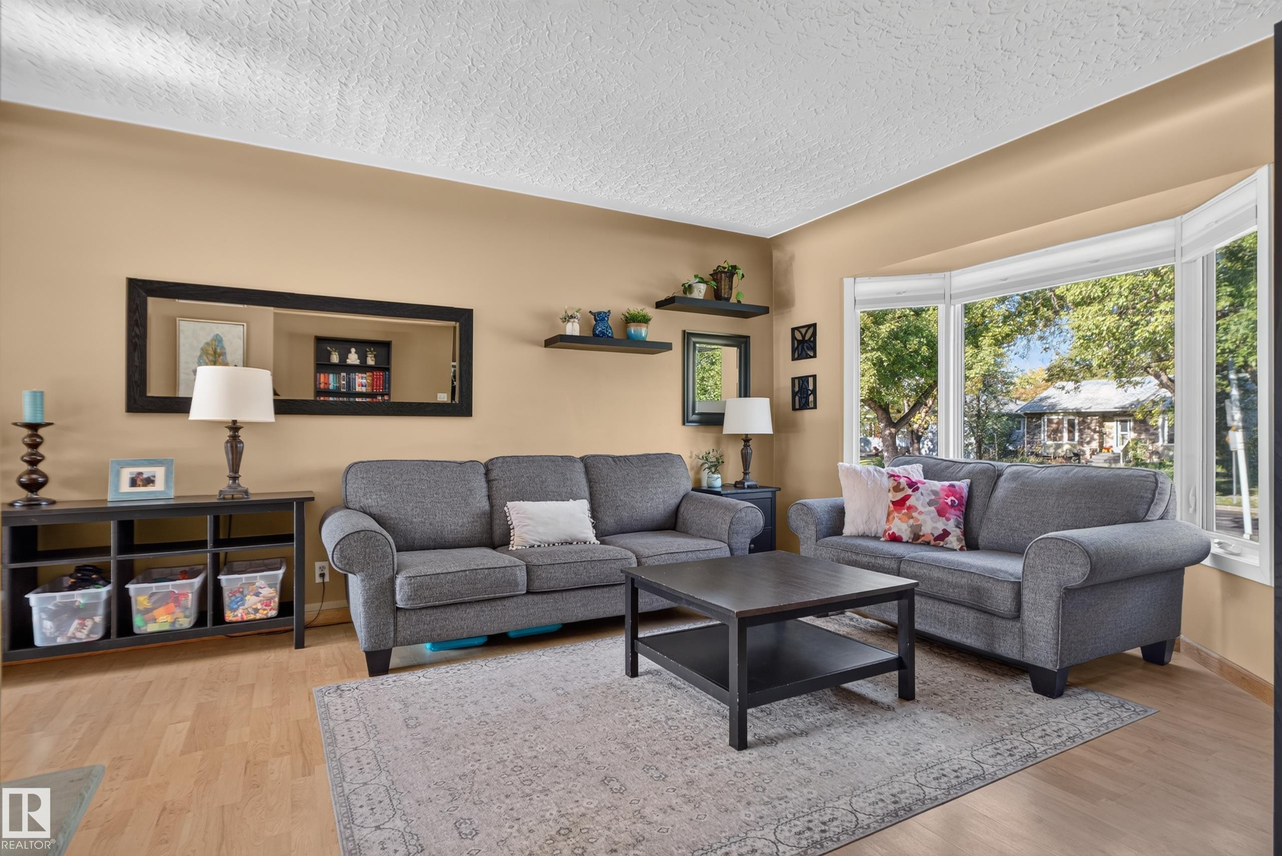 Wood-finish flooring, bay window, light neutral wall color, built-in shelving, and white ceiling - 14611 109 Avenue Nw, Edmonton, AB