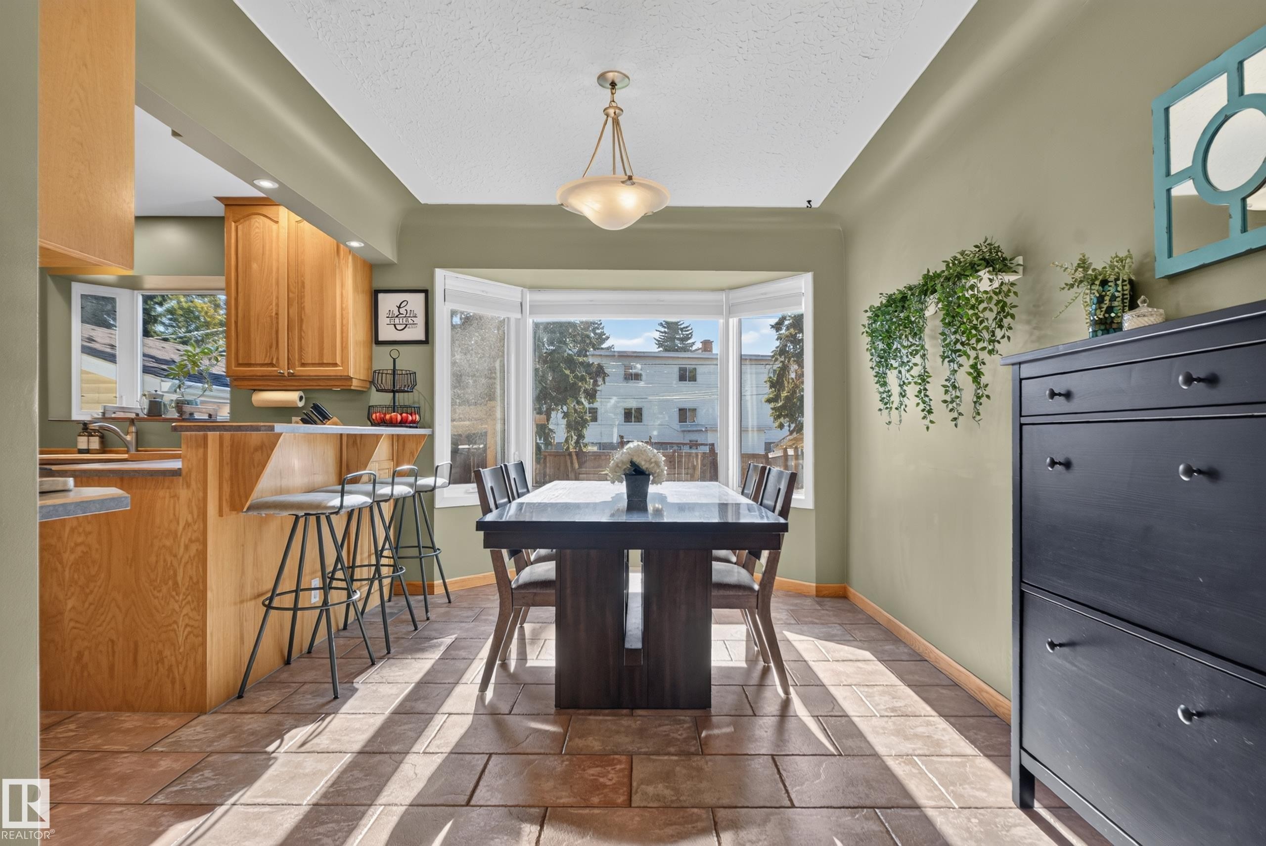Tile flooring, bay window, light wood cabinetry, recessed lighting, and a kitchen island with bar seating - 14611 109 Avenue Nw, Edmonton, AB