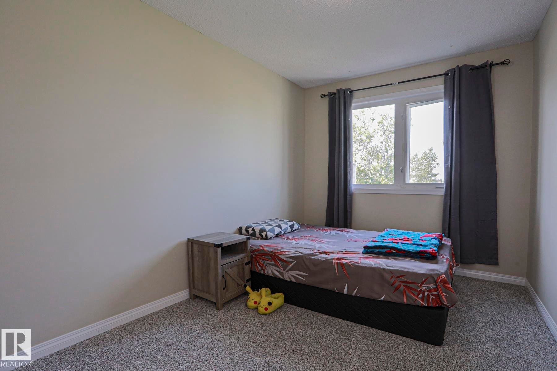 Neutral wall paint, window with trim, and carpeted flooring - 319 Telford Court, Leduc, AB