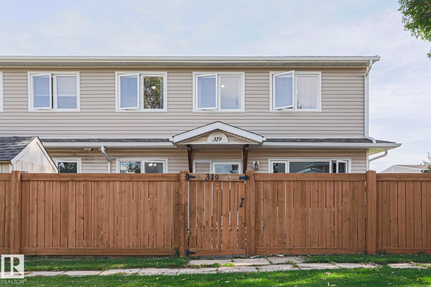 Light-colored siding exterior with white window frames - 319 Telford Court, Leduc, AB