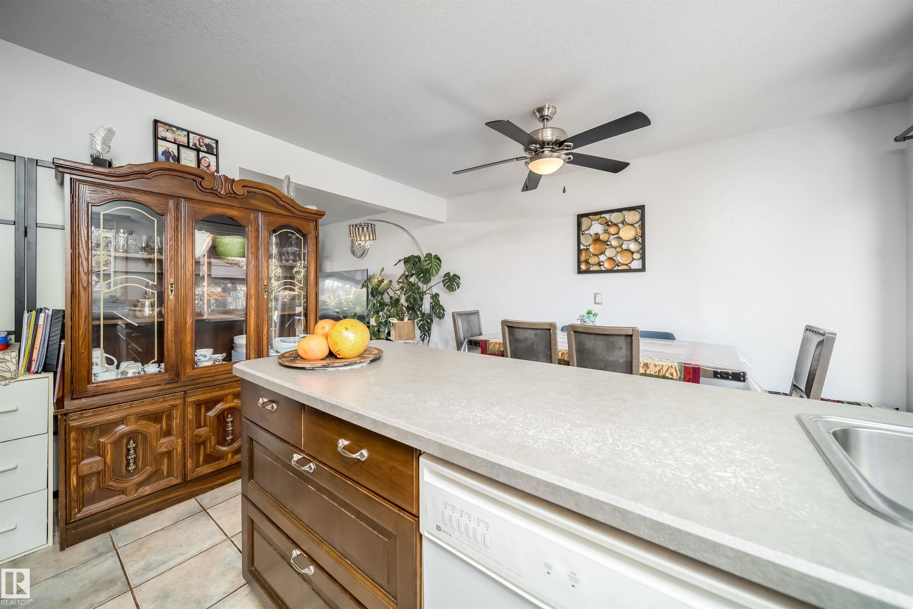Kitchen island with integrated sink and dishwasher, featuring a light-toned countertop - 10245 160 Street Nw, Edmonton, AB