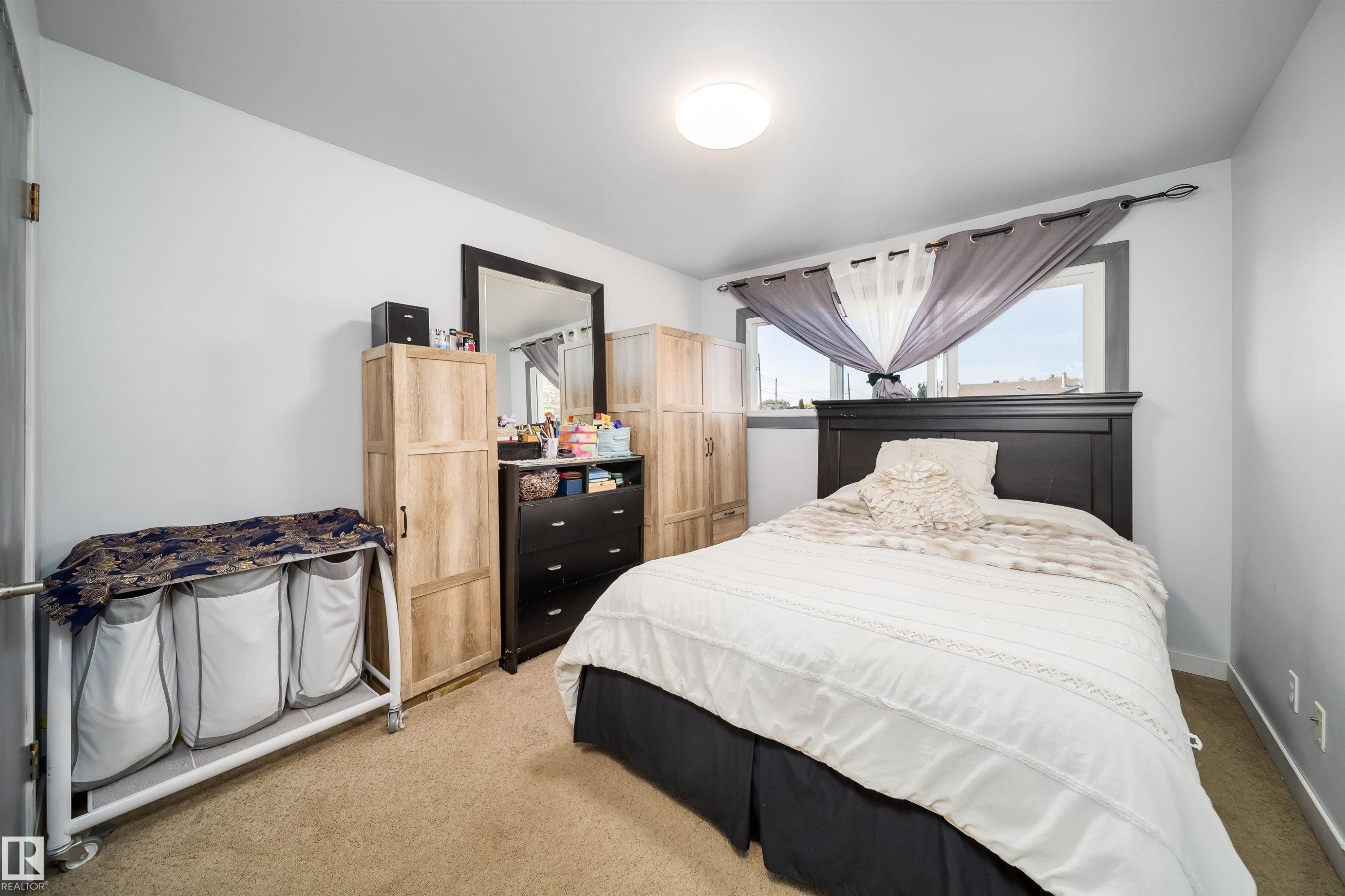Carpeted flooring, a window with dark trim, and a flush-mount ceiling light fixture - 10245 160 Street Nw, Edmonton, AB