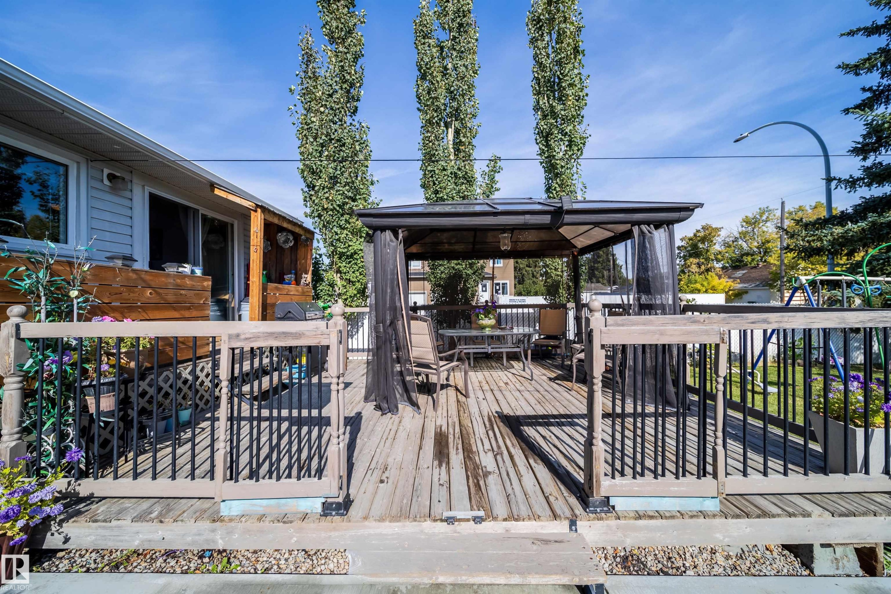 Expansive rear deck featuring wood decking, a built-in privacy screen, and durable railings - 10245 160 Street Nw, Edmonton, AB