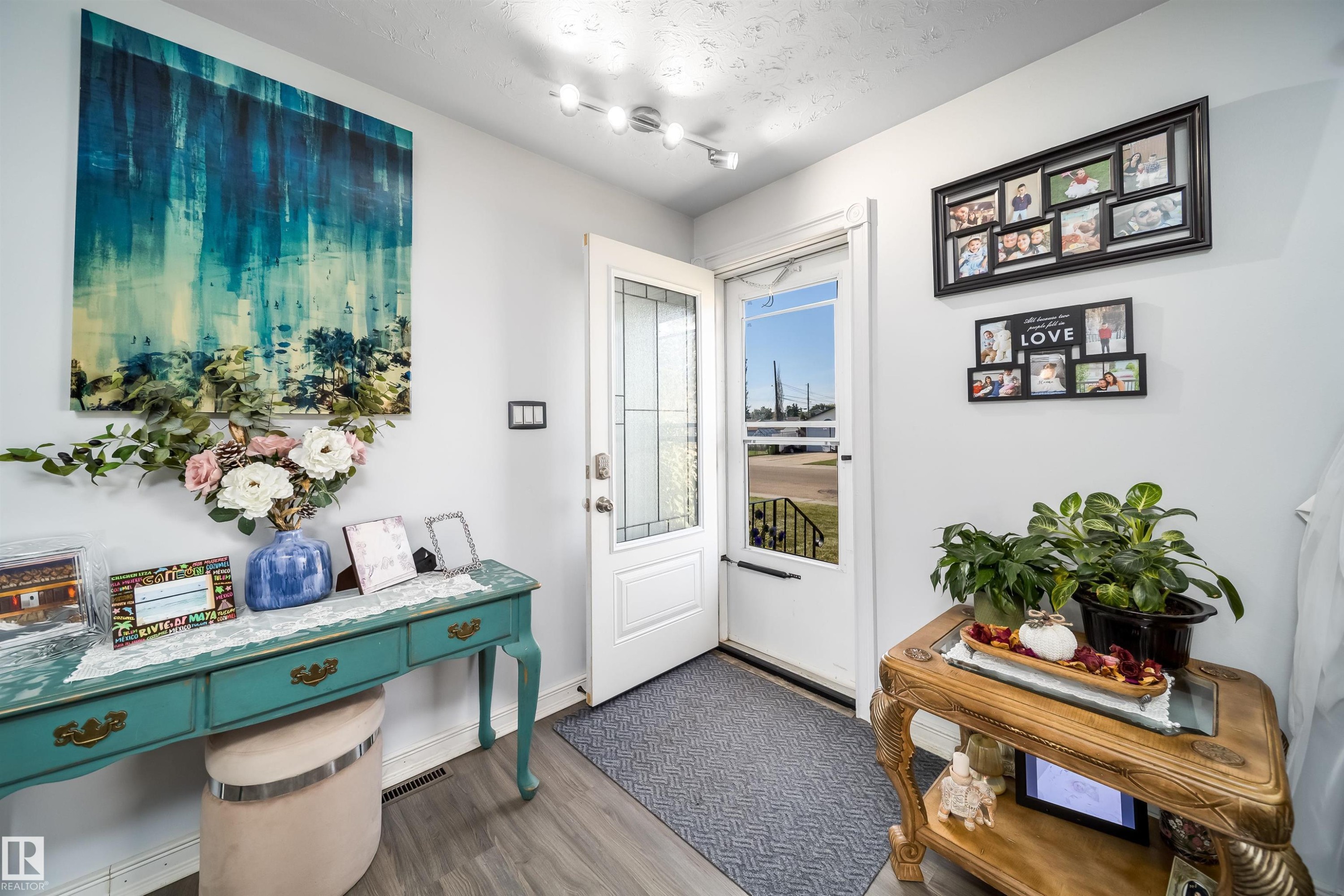 Entryway featuring wood-finish flooring, a white paneled door with decorative glass inserts, and track lighting - 10245 160 Street Nw, Edmonton, AB