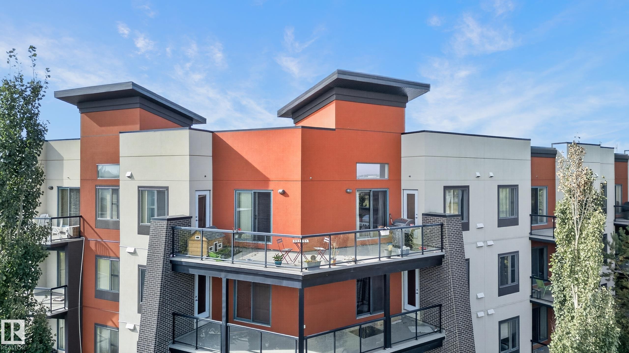 Contemporary multi-story building featuring multiple balconies with glass railings - #411 304 Ambleside Link Li Sw, Edmonton, AB