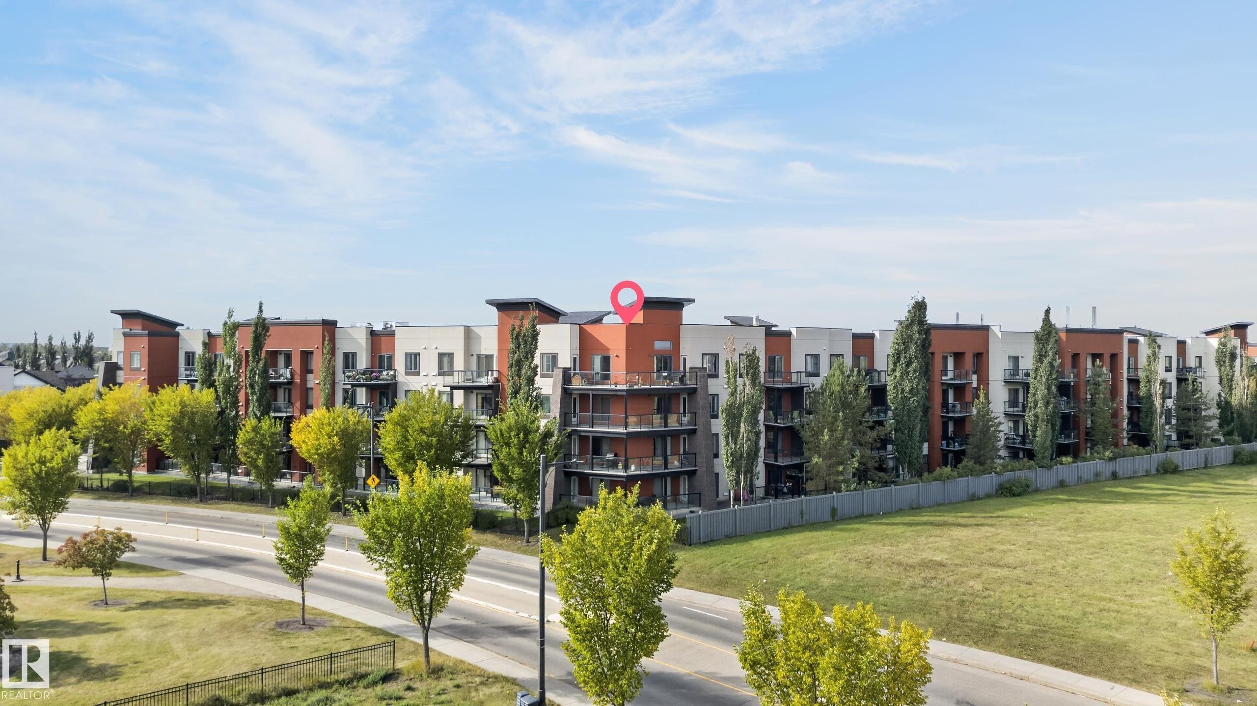 Multi-story building featuring balconies, a neutral color palette, and vertical architectural elements - #411 304 Ambleside Link Li Sw, Edmonton, AB