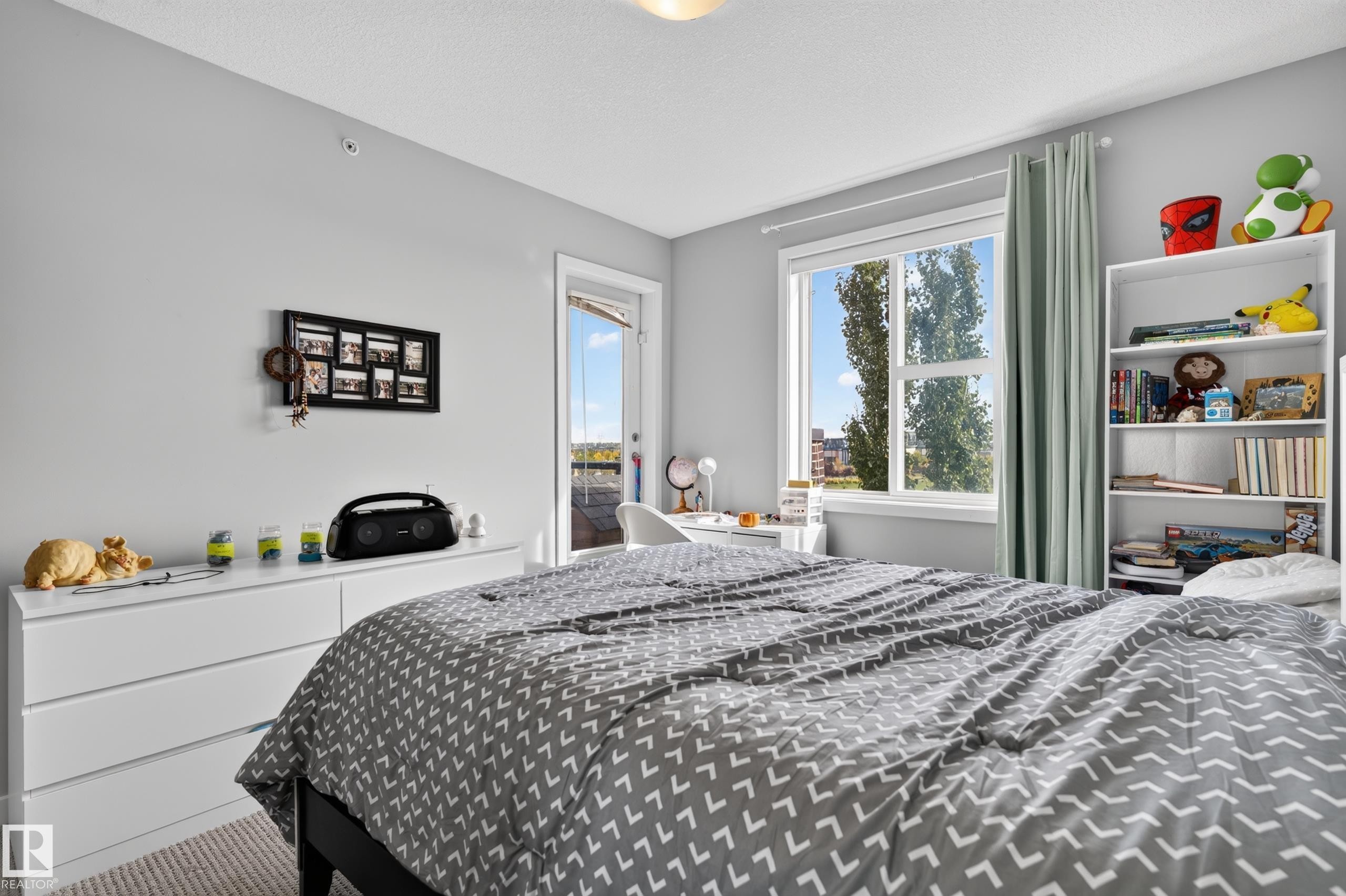 Light gray wall finishes with a window and a door to an outdoor space - #411 304 Ambleside Link Li Sw, Edmonton, AB