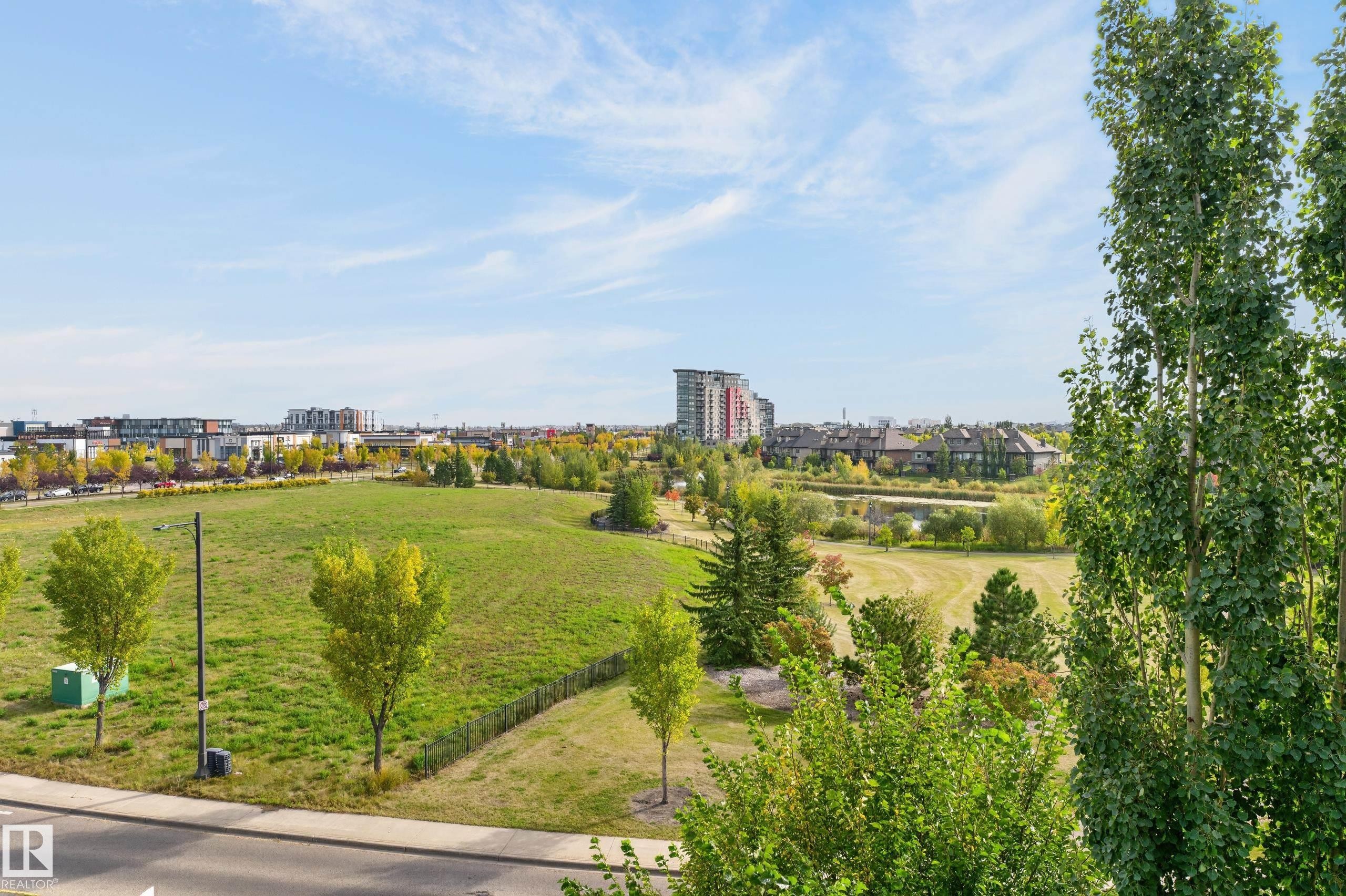 Expansive green space with mature trees and paved pathways - #411 304 Ambleside Link Li Sw, Edmonton, AB
