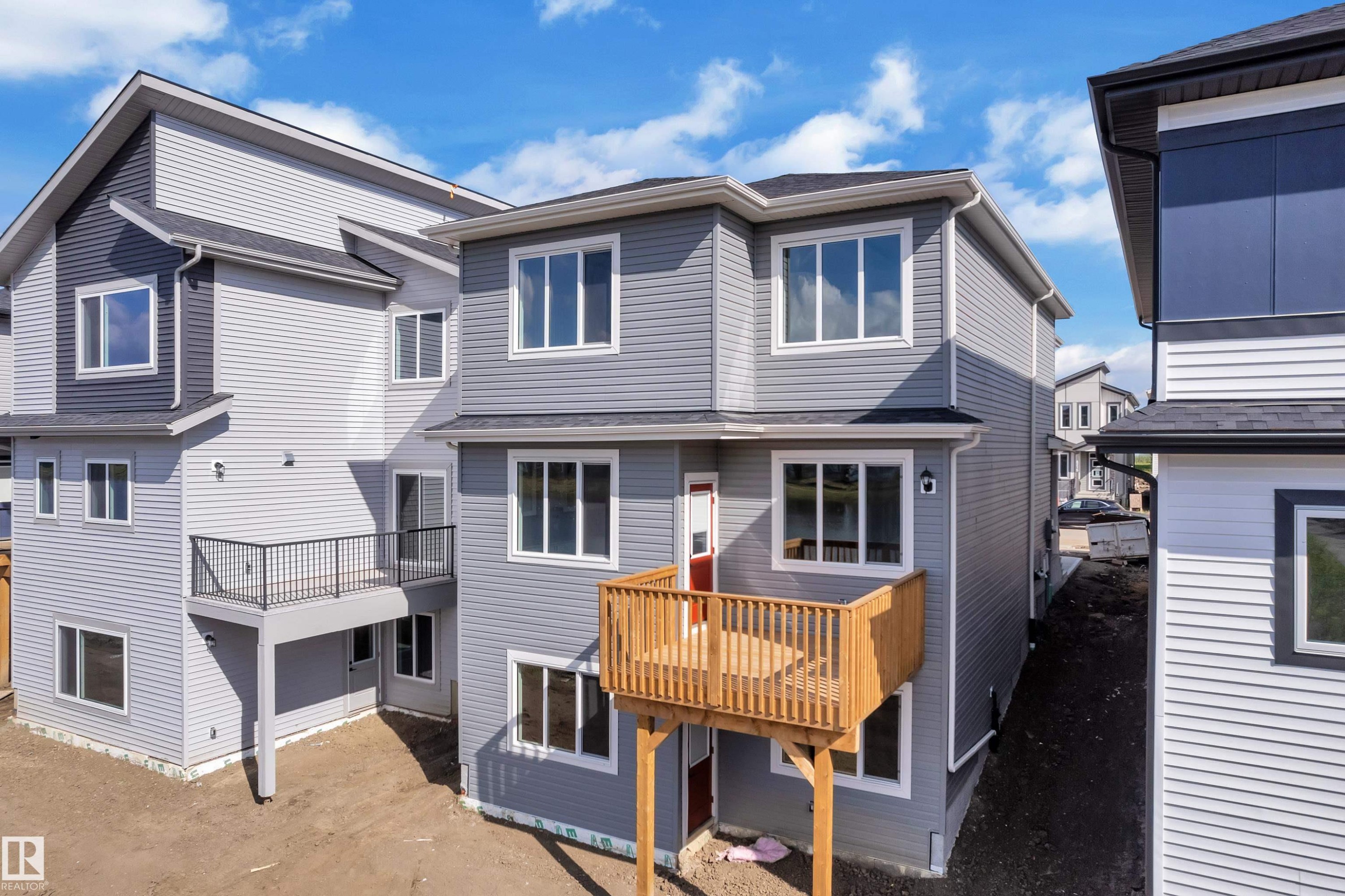 Contemporary multi-level exterior with light gray and dark gray siding - 4212 63 Street, Beaumont, AB