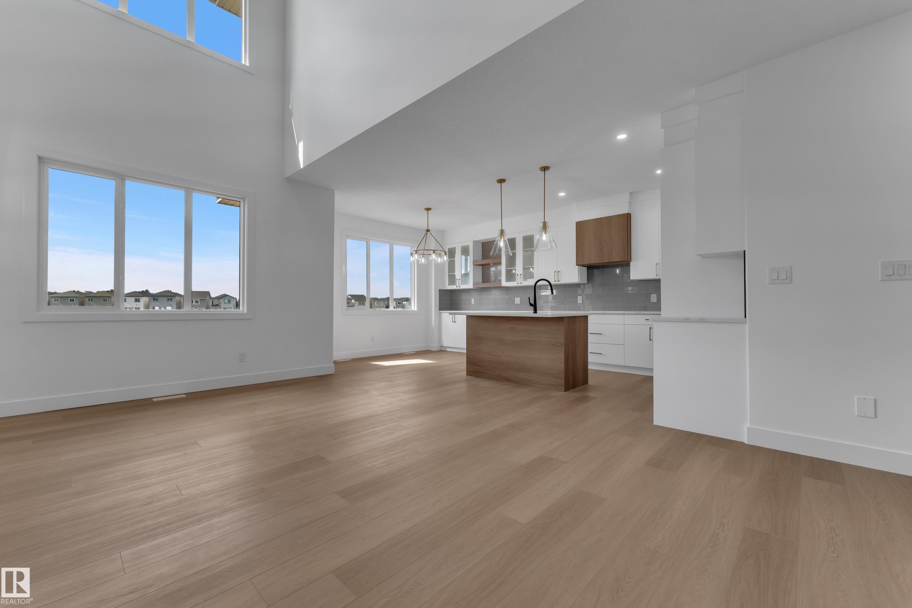 High ceilings, wood-finish flooring, recessed lighting, island with wood-finish base, white cabinetry - 4212 63 Street, Beaumont, AB