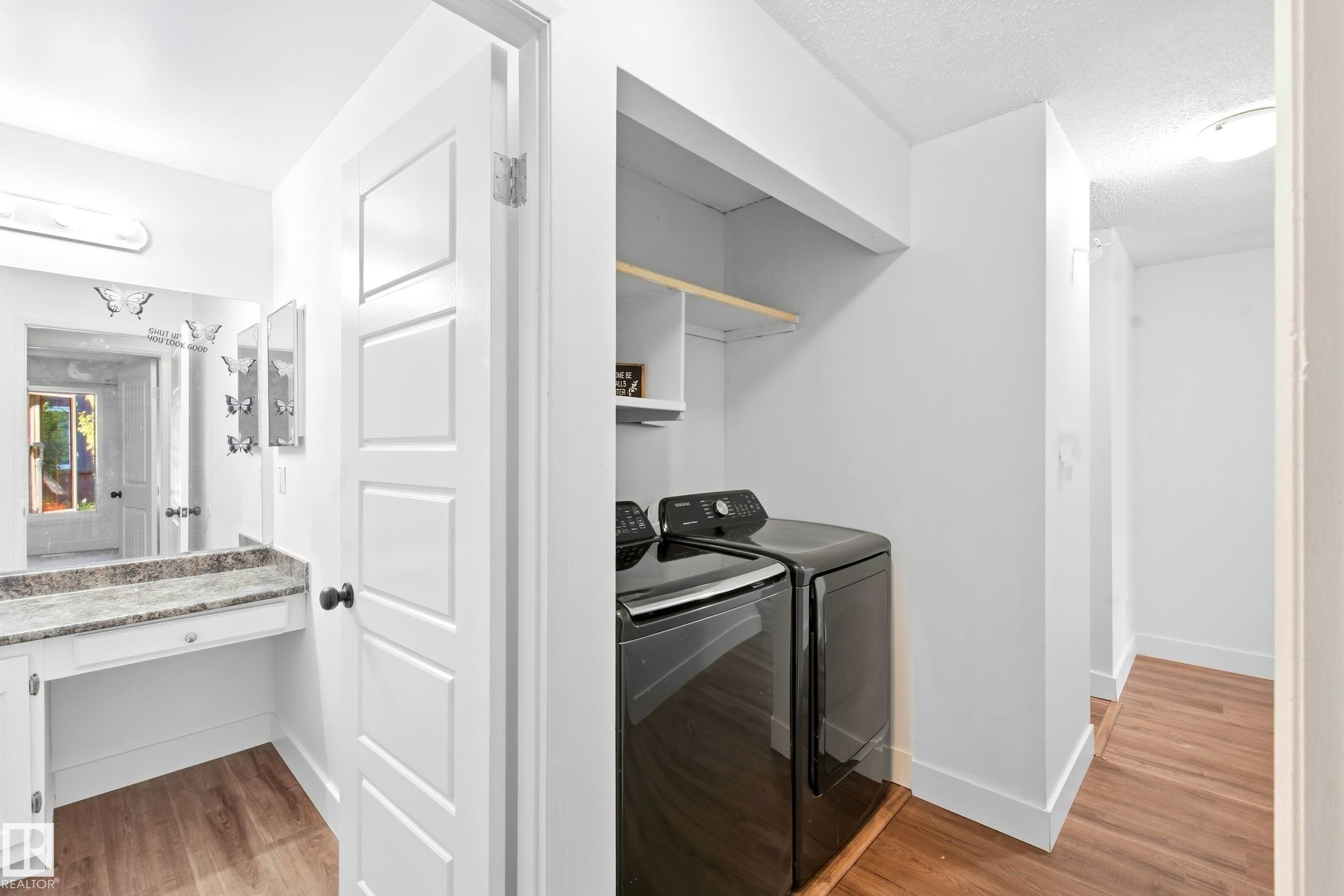 Built-in vanity with a stone countertop, integrated sink, and white cabinetry - 258 Surrey Gardens Nw, Edmonton, AB