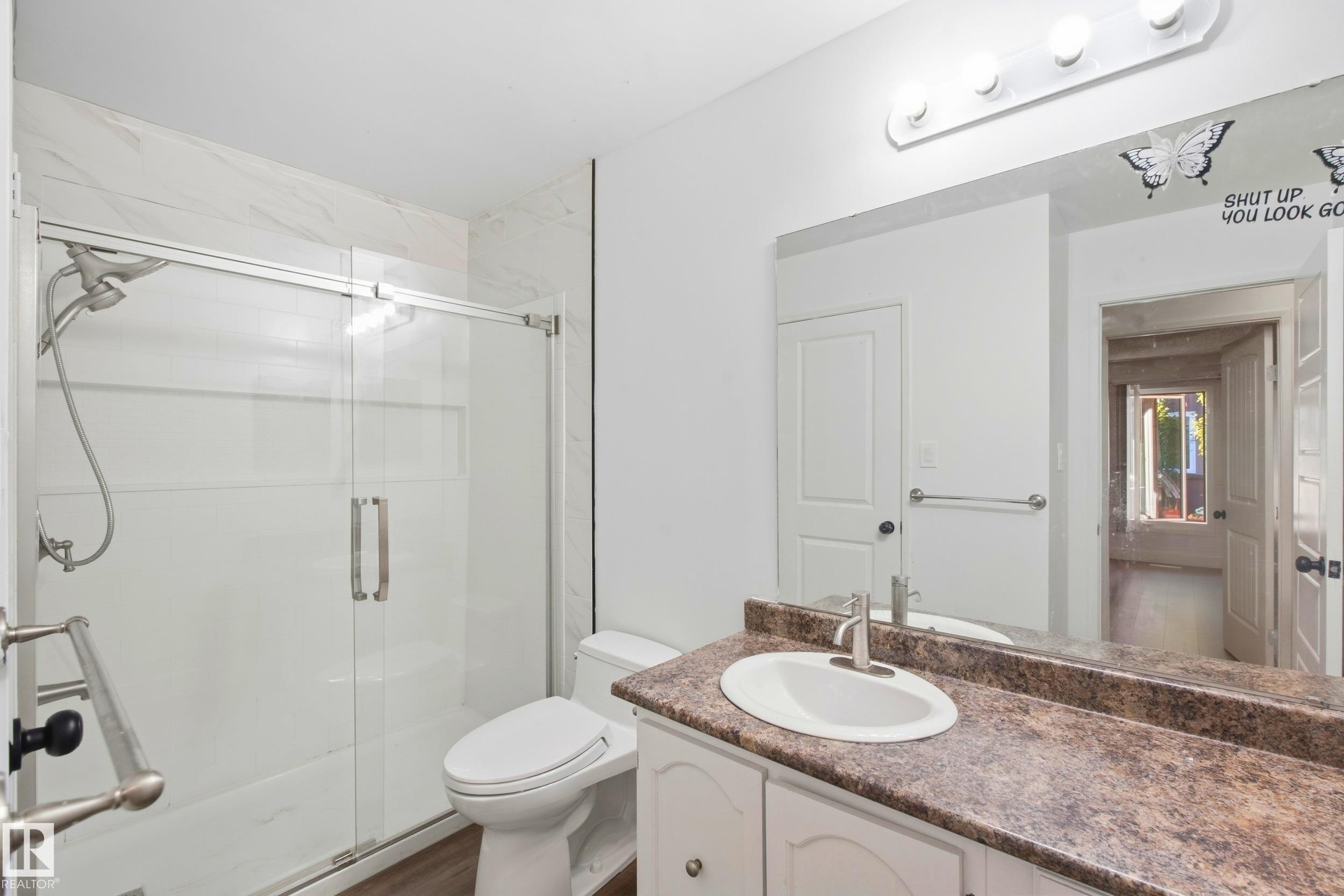 Vanity with integrated sink and countertop, full-width mirror, and overhead vanity lighting - 258 Surrey Gardens Nw, Edmonton, AB