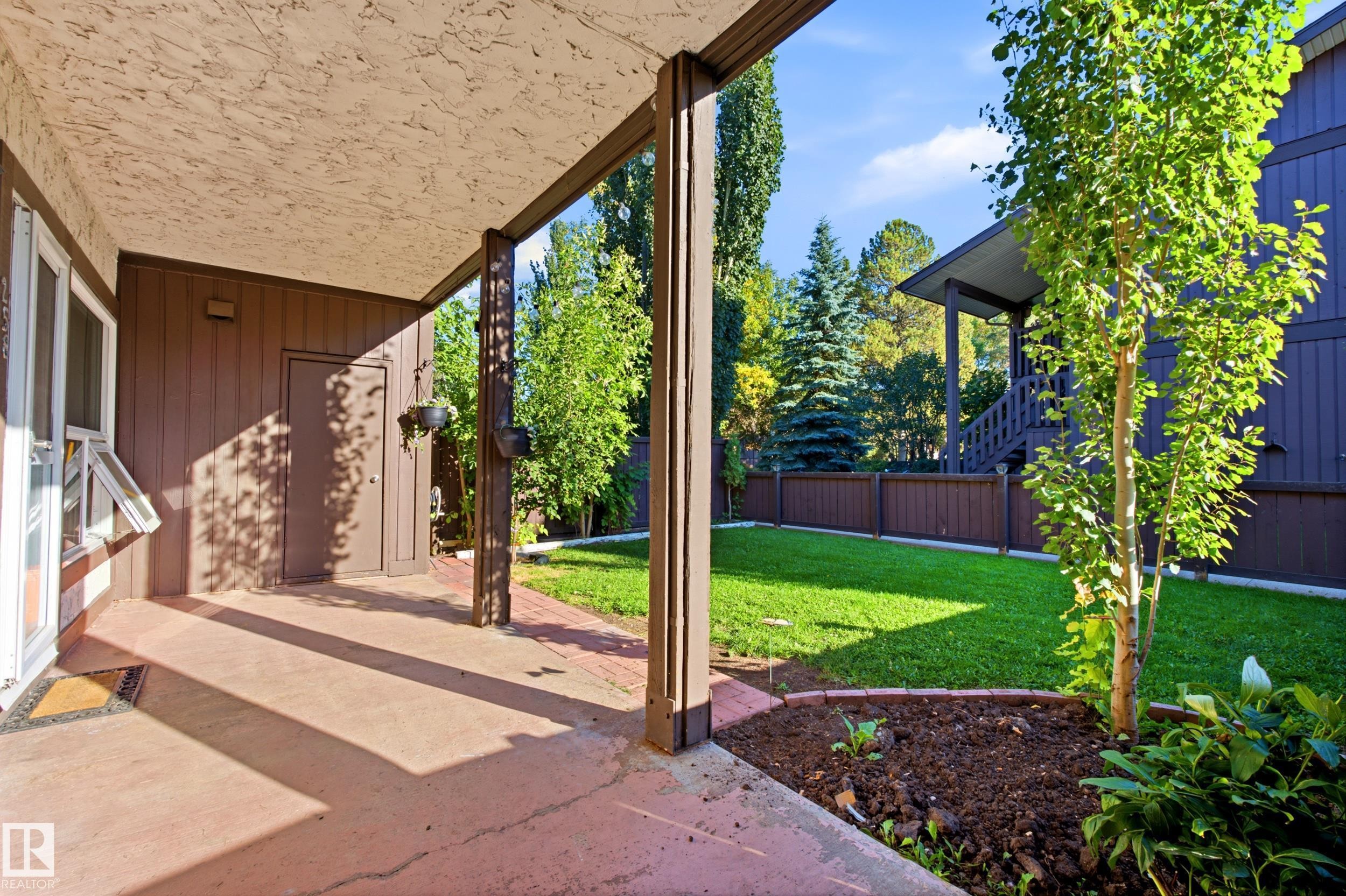 Covered patio with textured ceiling, concrete flooring, and an adjacent grassy area - 258 Surrey Gardens Nw, Edmonton, AB
