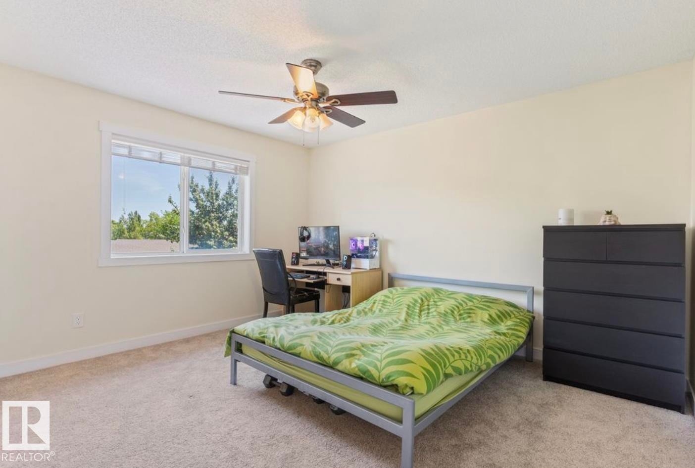 Carpeted room featuring a large window, a ceiling fan, and light-toned walls - 1007 Macewan Close Sw, Edmonton, AB - Indoor Photo Showing Bedroom