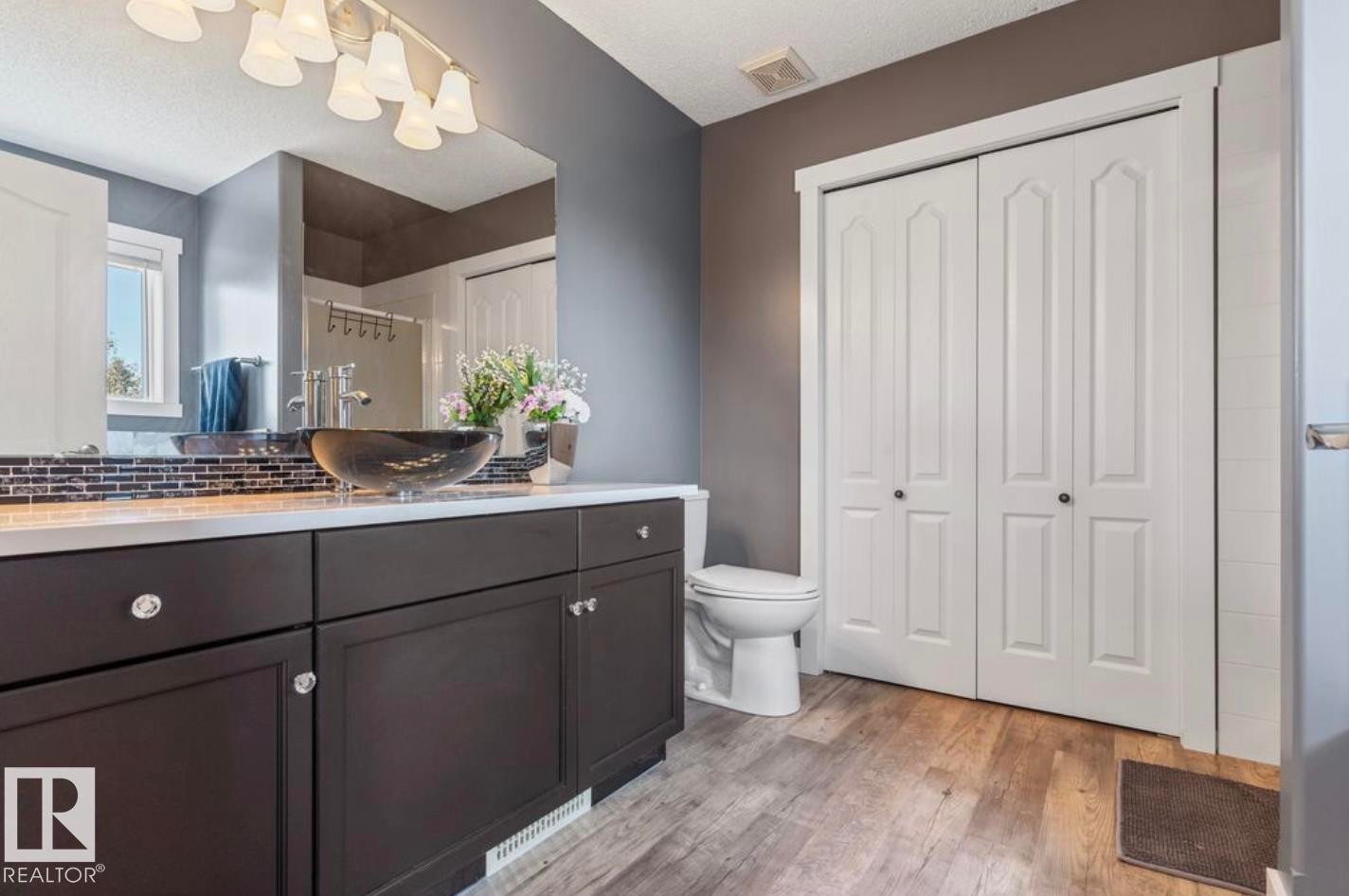 Bathroom featuring a dark wood-finish vanity with a white countertop and vessel sink - 1007 Macewan Close Sw, Edmonton, AB - Indoor Photo Showing Bathroom