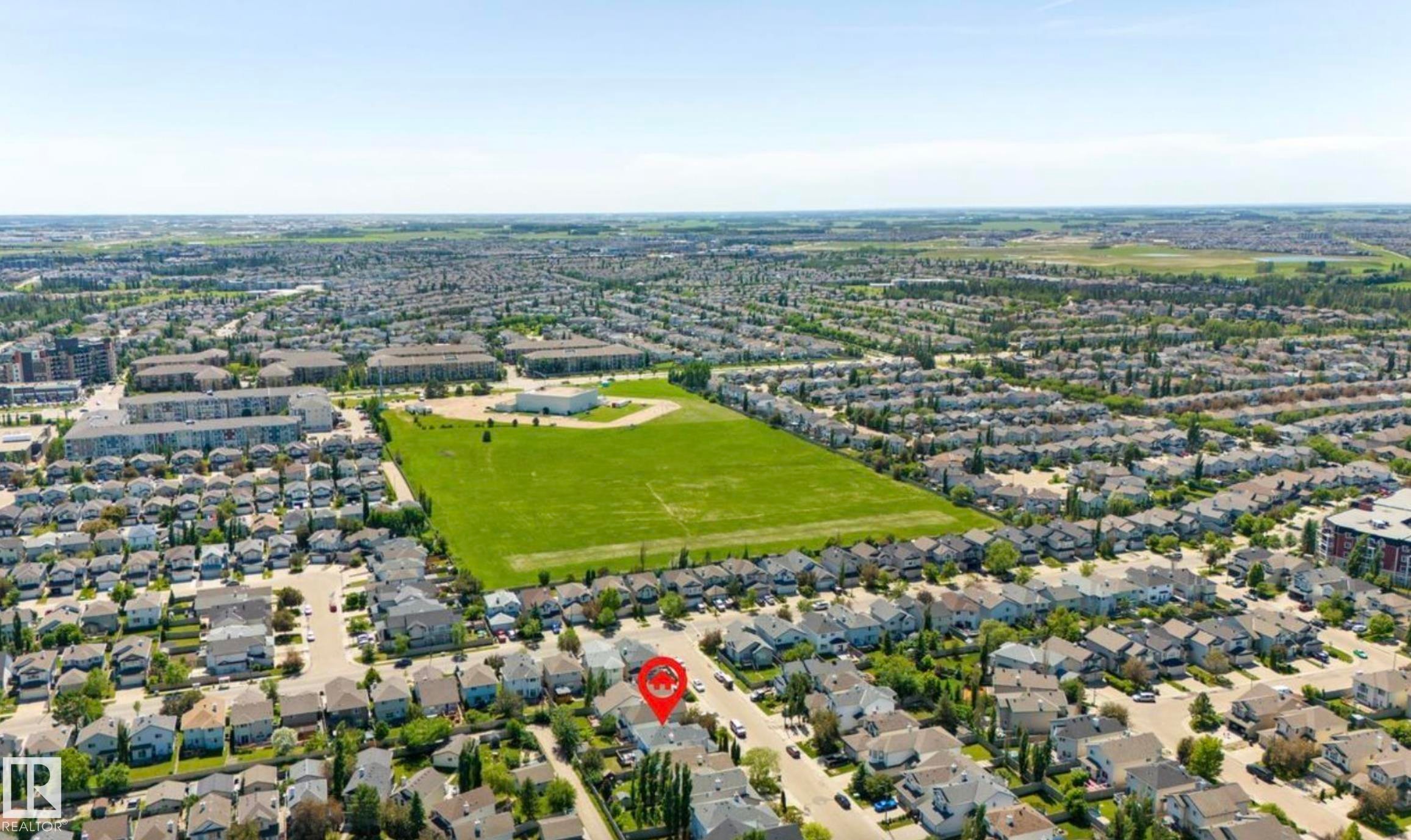 Aerial perspective showcasing a residential neighborhood with detached homes, green spaces, and community buildings - 1007 Macewan Close Sw, Edmonton, AB - Outdoor With View