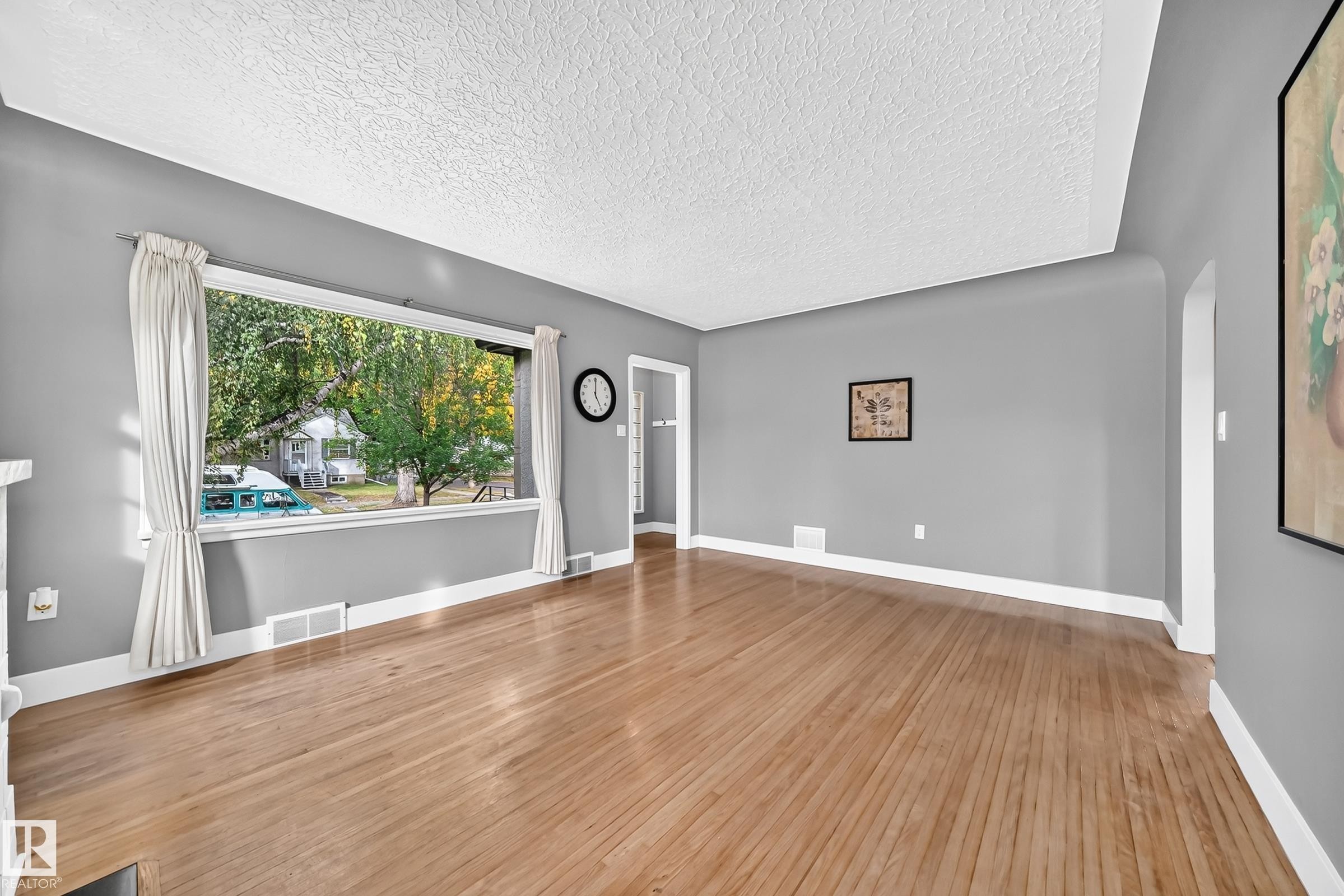 Bright natural Light Living Rood with Original Refinished Hardwood Flooring - 12045 64 Street Nw, Edmonton, AB