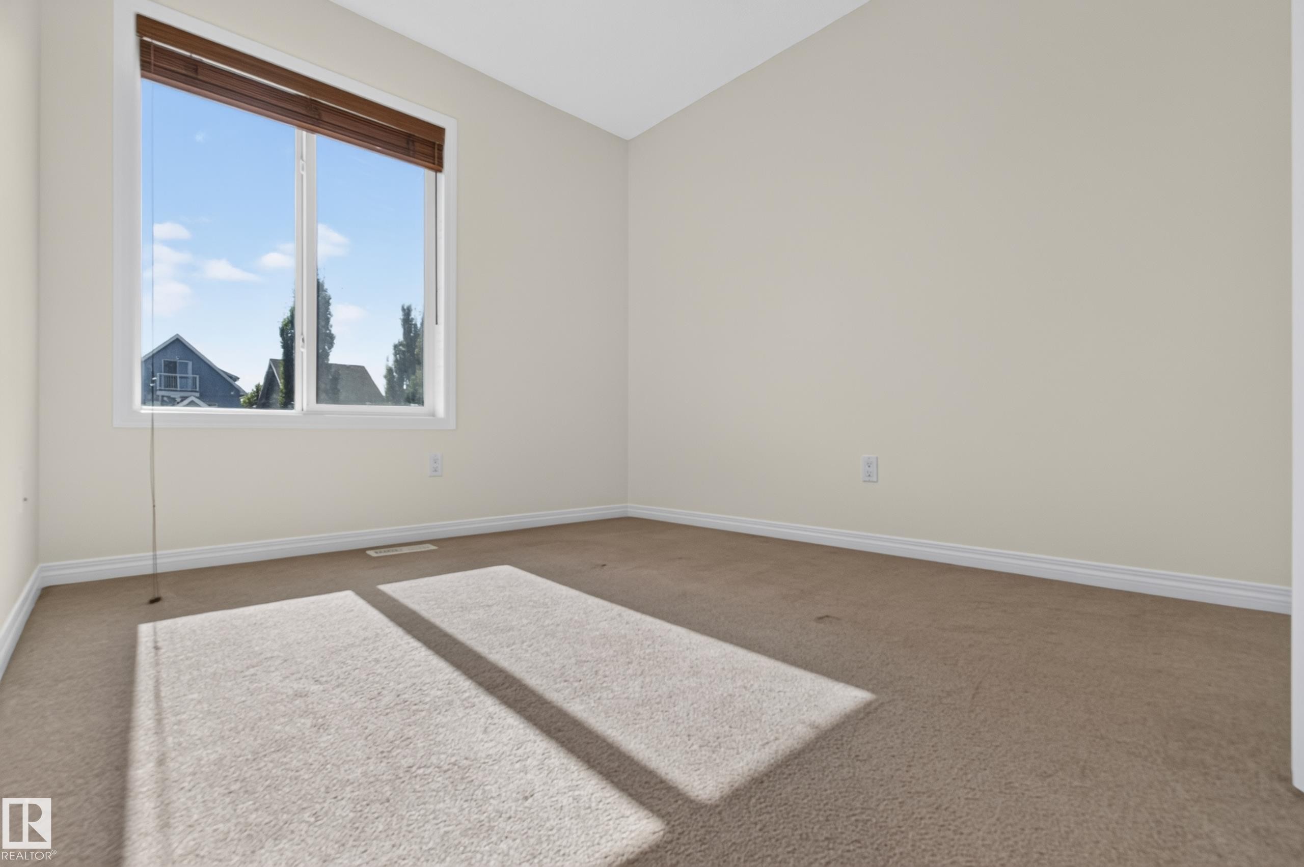 Bright room featuring a large window with brown wood blinds and neutral carpeting - 6933 21A Avenue Sw, Edmonton, AB