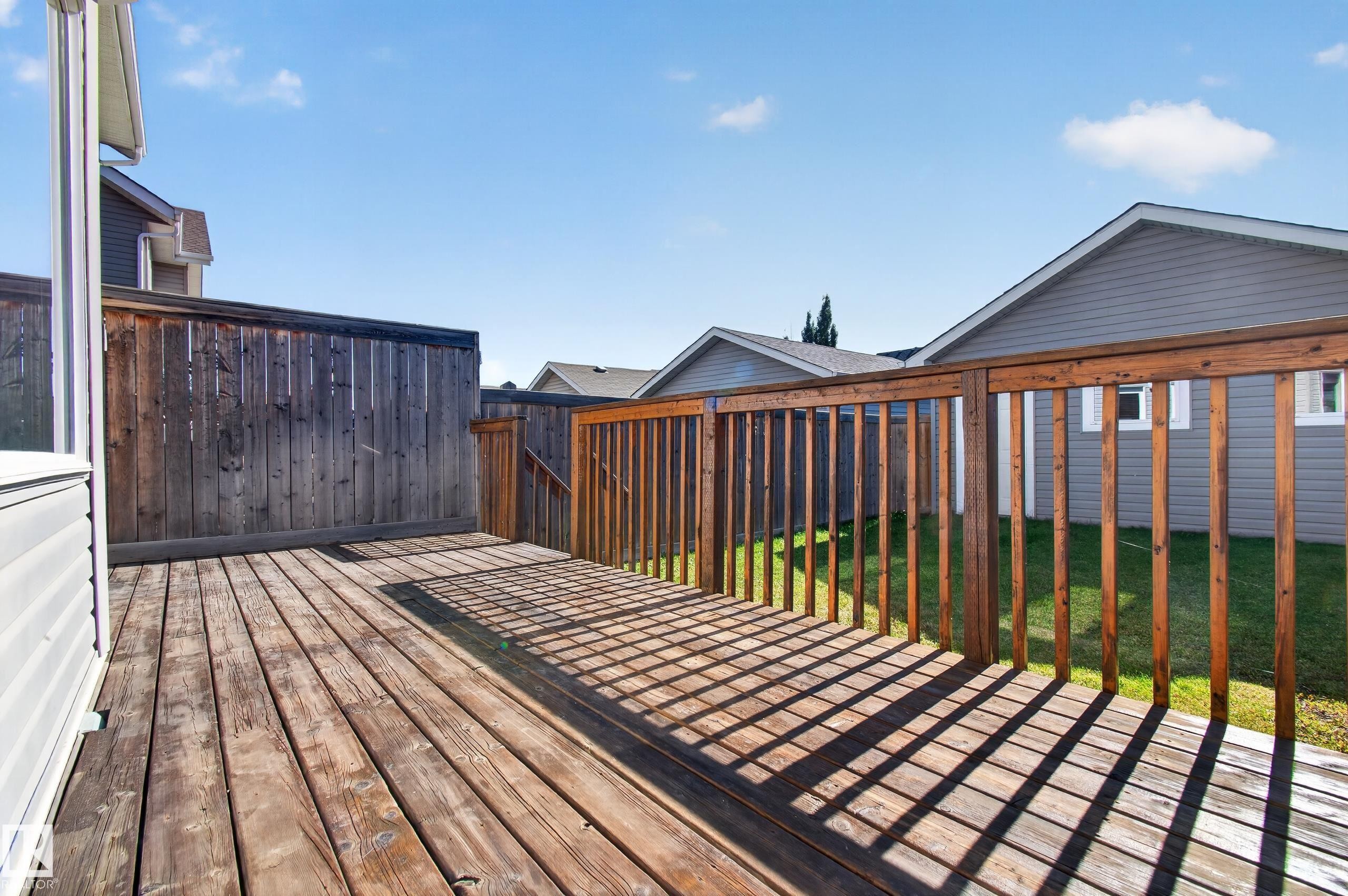 Wood-plank deck with a wood railing and privacy fencing - 6933 21A Avenue Sw, Edmonton, AB