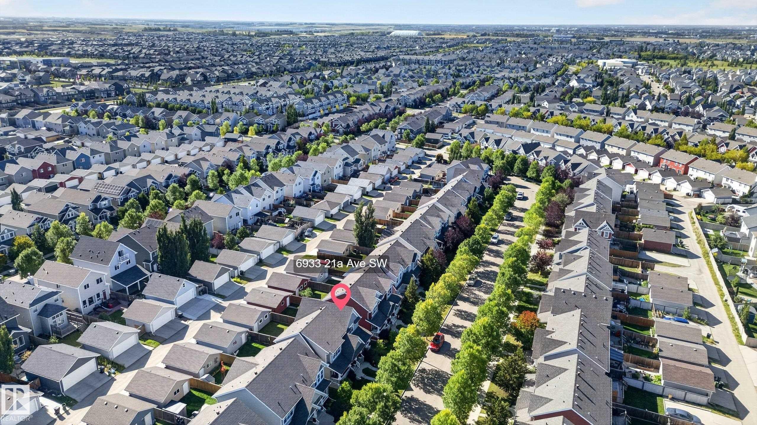 Residential neighborhood with varied architectural styles, mature street trees, and a consistent street grid layout - 6933 21A Avenue Sw, Edmonton, AB