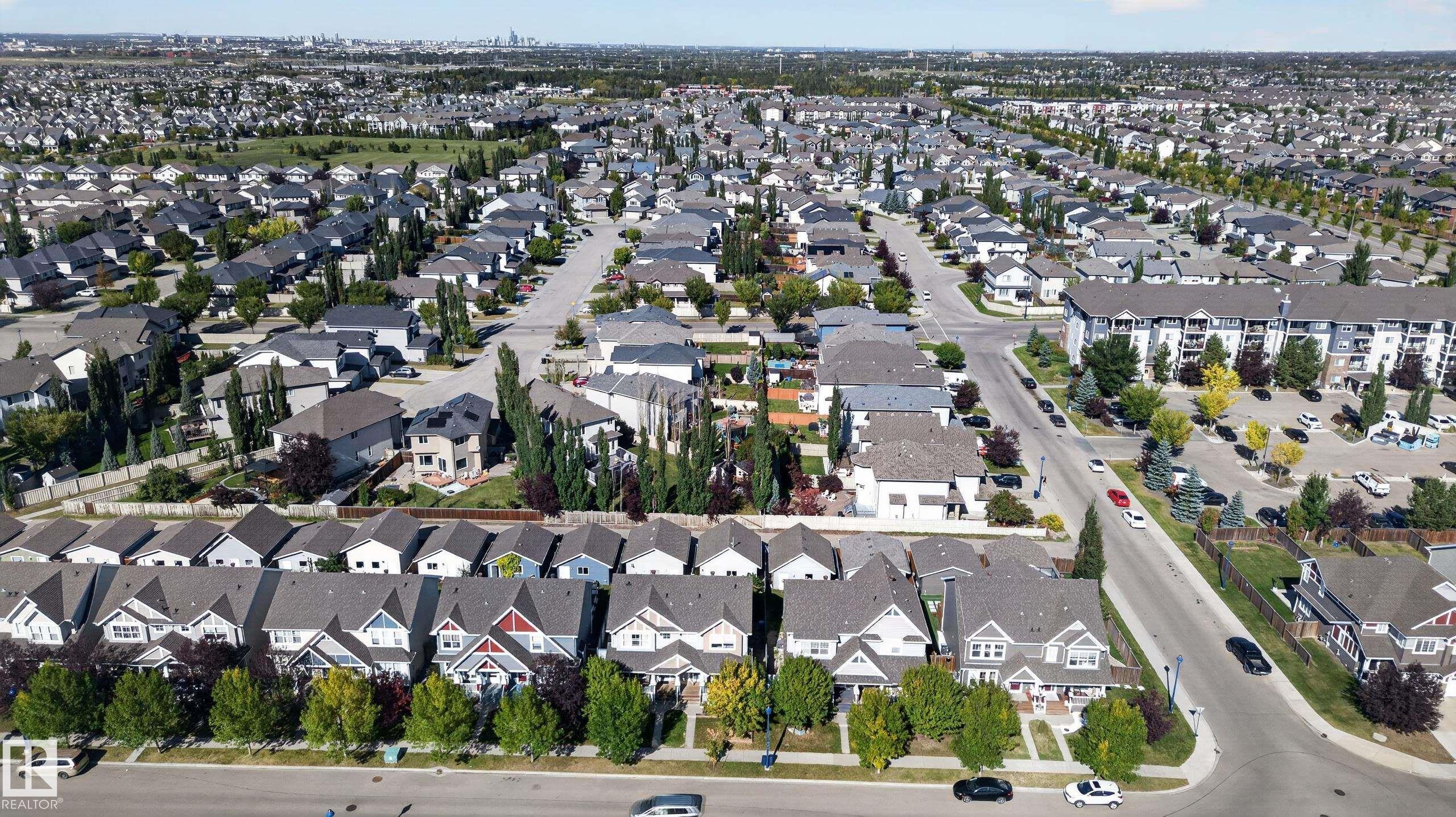 Expansive residential area featuring numerous detached homes with diverse architectural styles, tree-lined streets, and multiple apartment buildings - 6933 21A Avenue Sw, Edmonton, AB