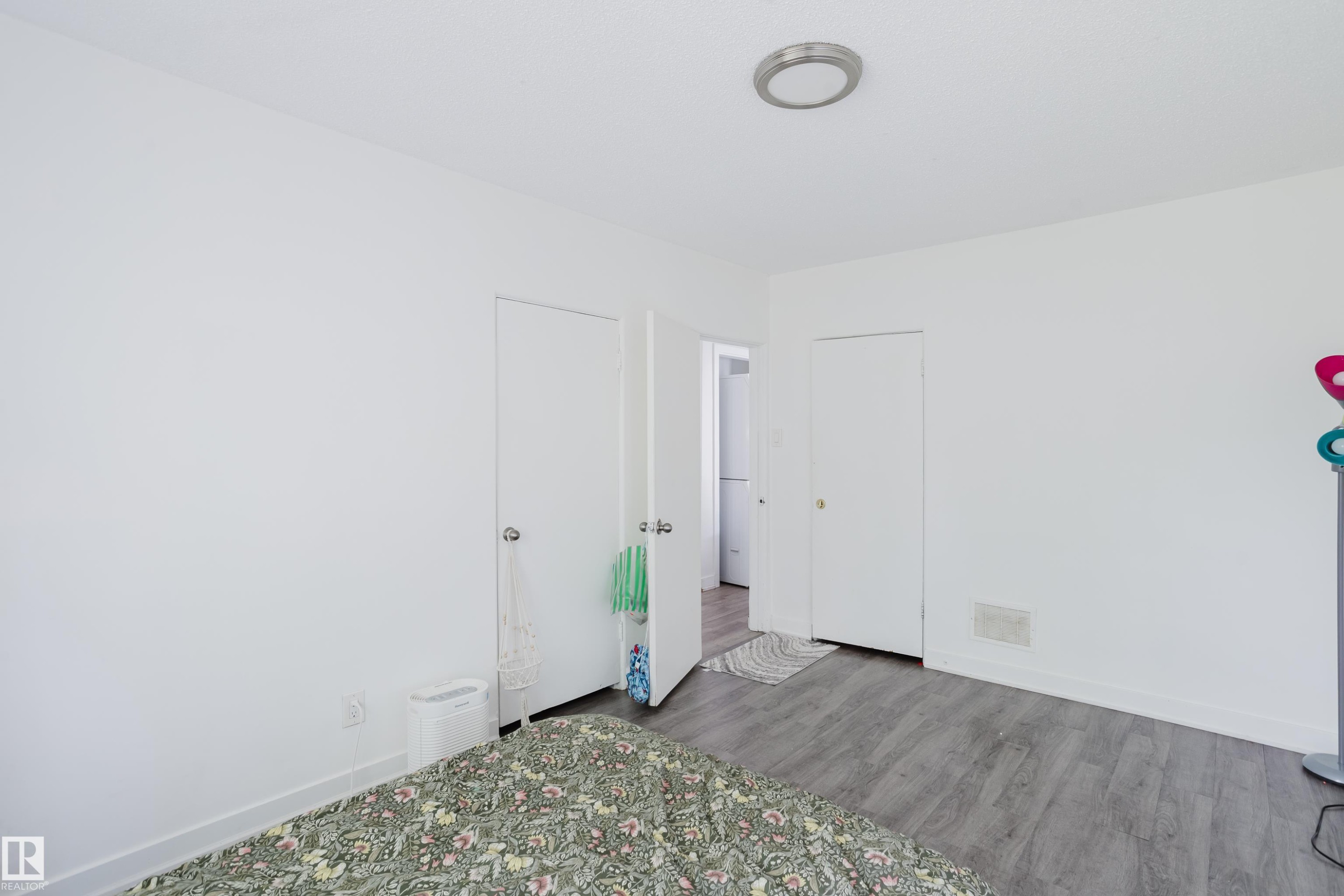 White painted walls, wood-finish flooring, two doors, and a ceiling-mounted light fixture - 11134 11138 116 Street Nw, Edmonton, AB