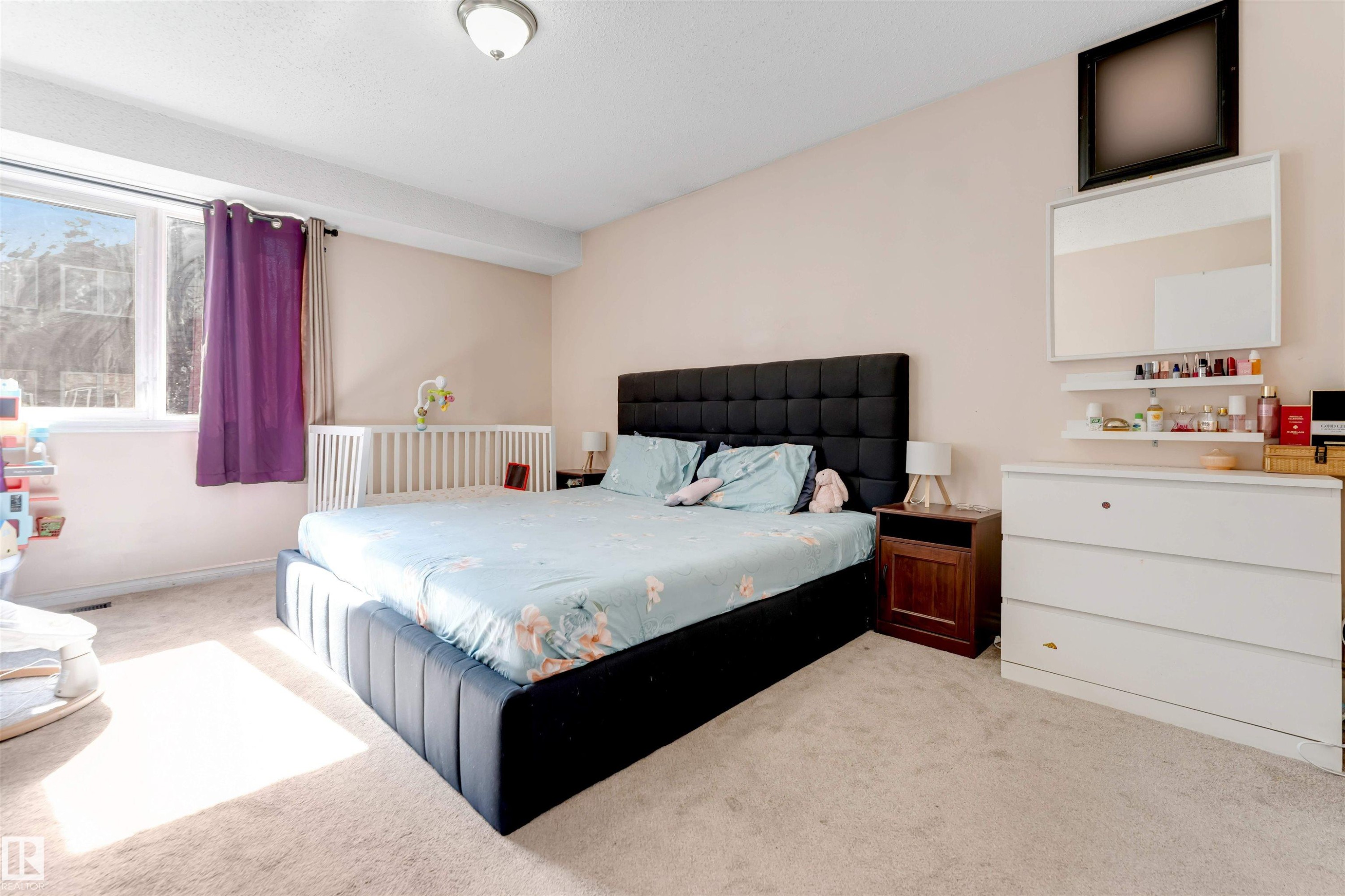 Carpeted flooring, recessed ceiling light, wide window with white trim, built-in shelving, and a wall-mounted mirror - #101 49 Akins Dr, St. Albert, AB