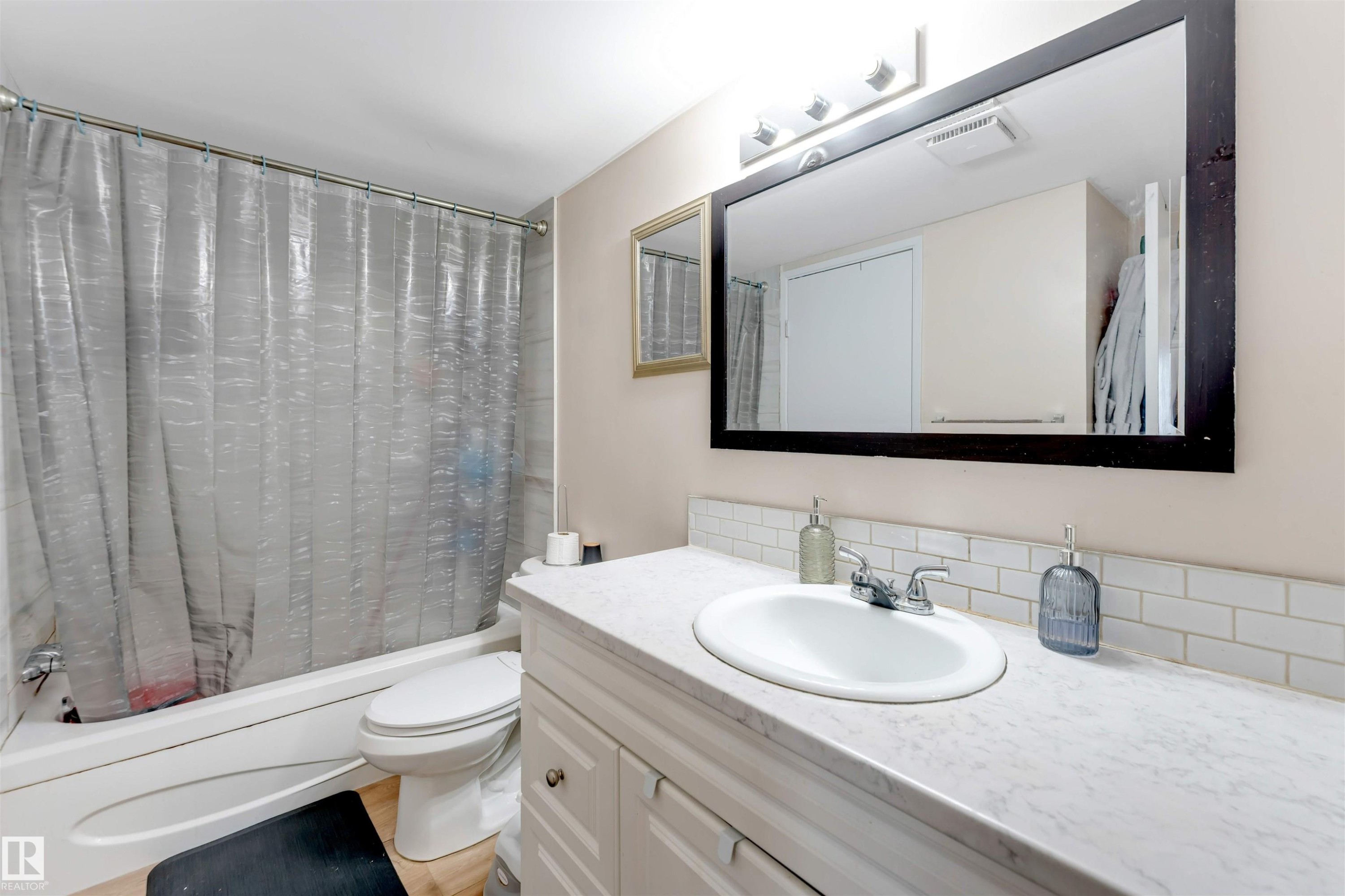 White vanity with chrome hardware, an integrated sink, and a white countertop - #101 49 Akins Dr, St. Albert, AB