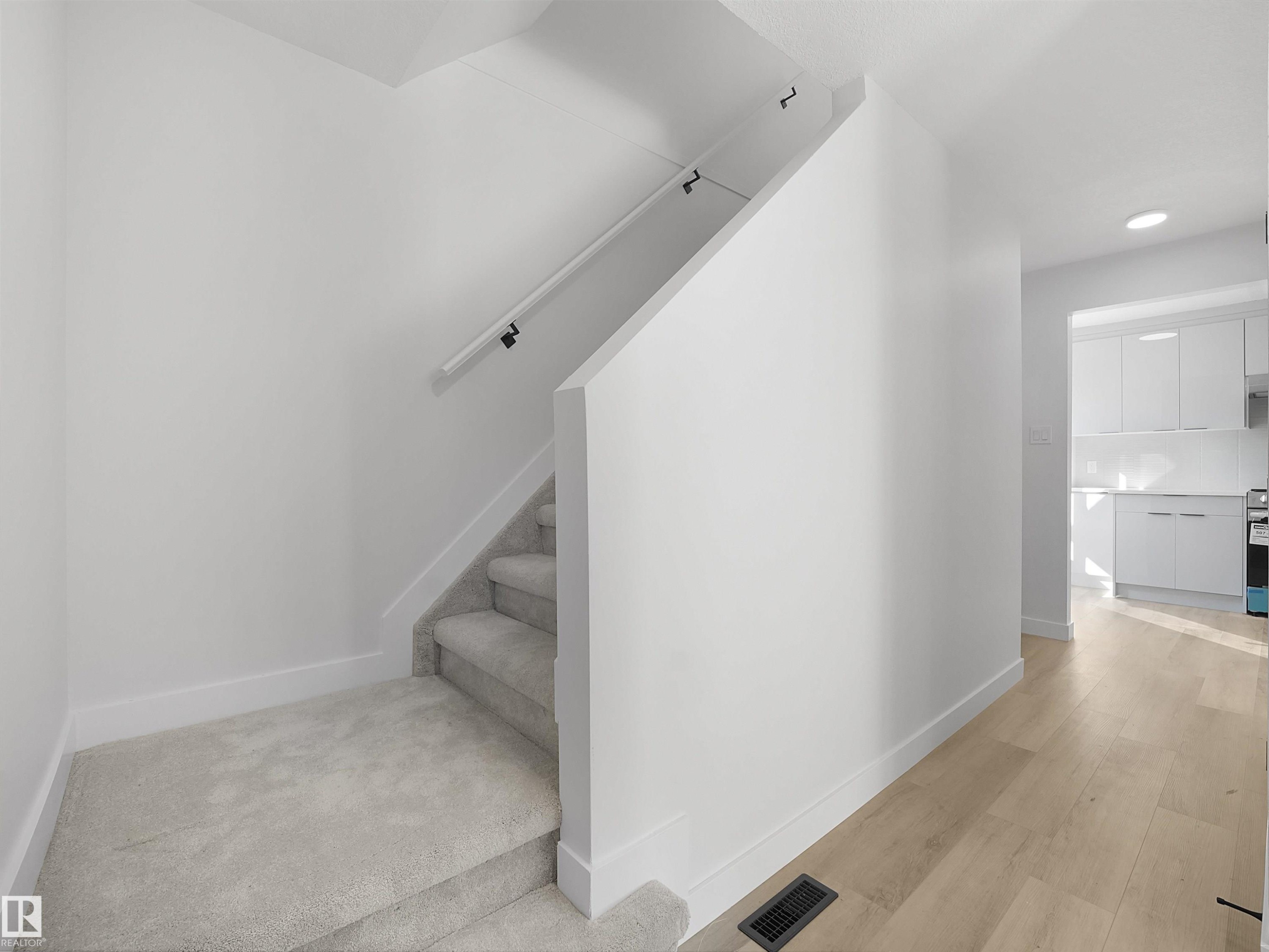 Carpeted staircase with a white handrail, wood-finish flooring, and recessed lighting - 12C Twin Terrace Nw, Edmonton, AB