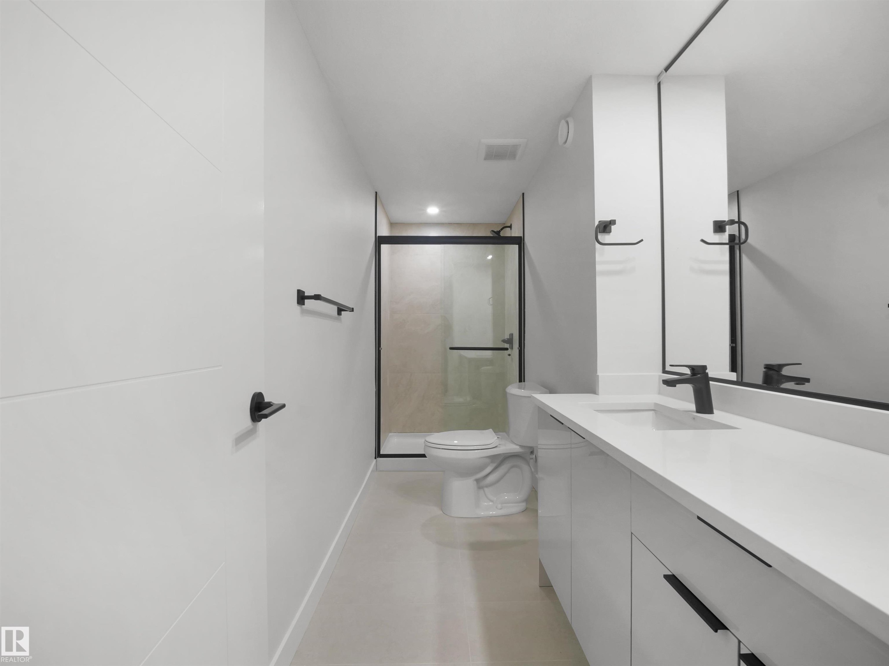White floating vanity with integrated sink, matte black faucet, frameless mirror, and glass-enclosed shower with black trim - 12C Twin Terrace Nw, Edmonton, AB