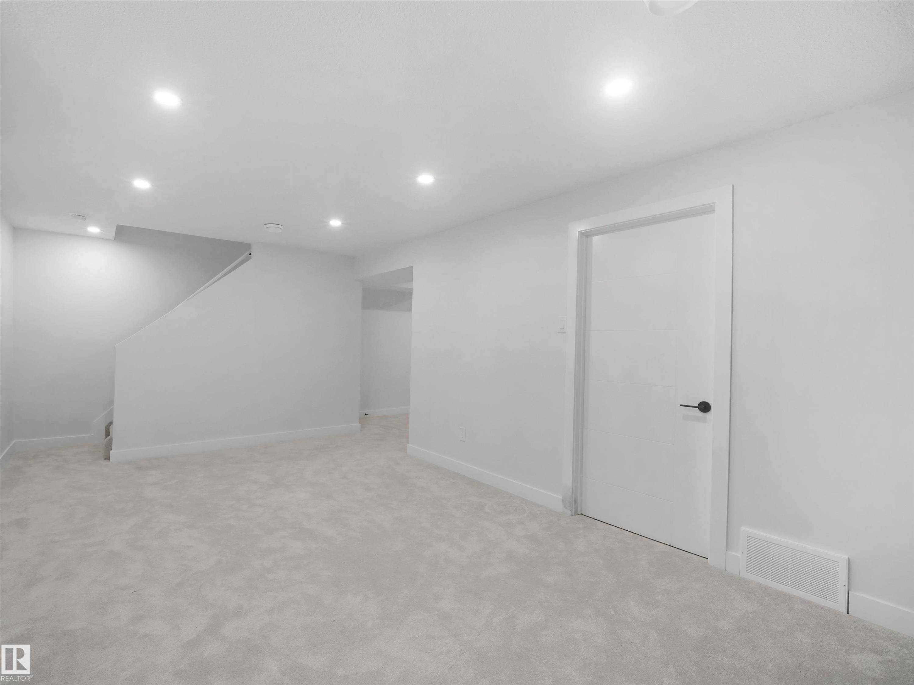 Recessed lighting, light gray carpeting, white walls, white trim, and a white interior door with matte black hardware - 12C Twin Terrace Nw, Edmonton, AB