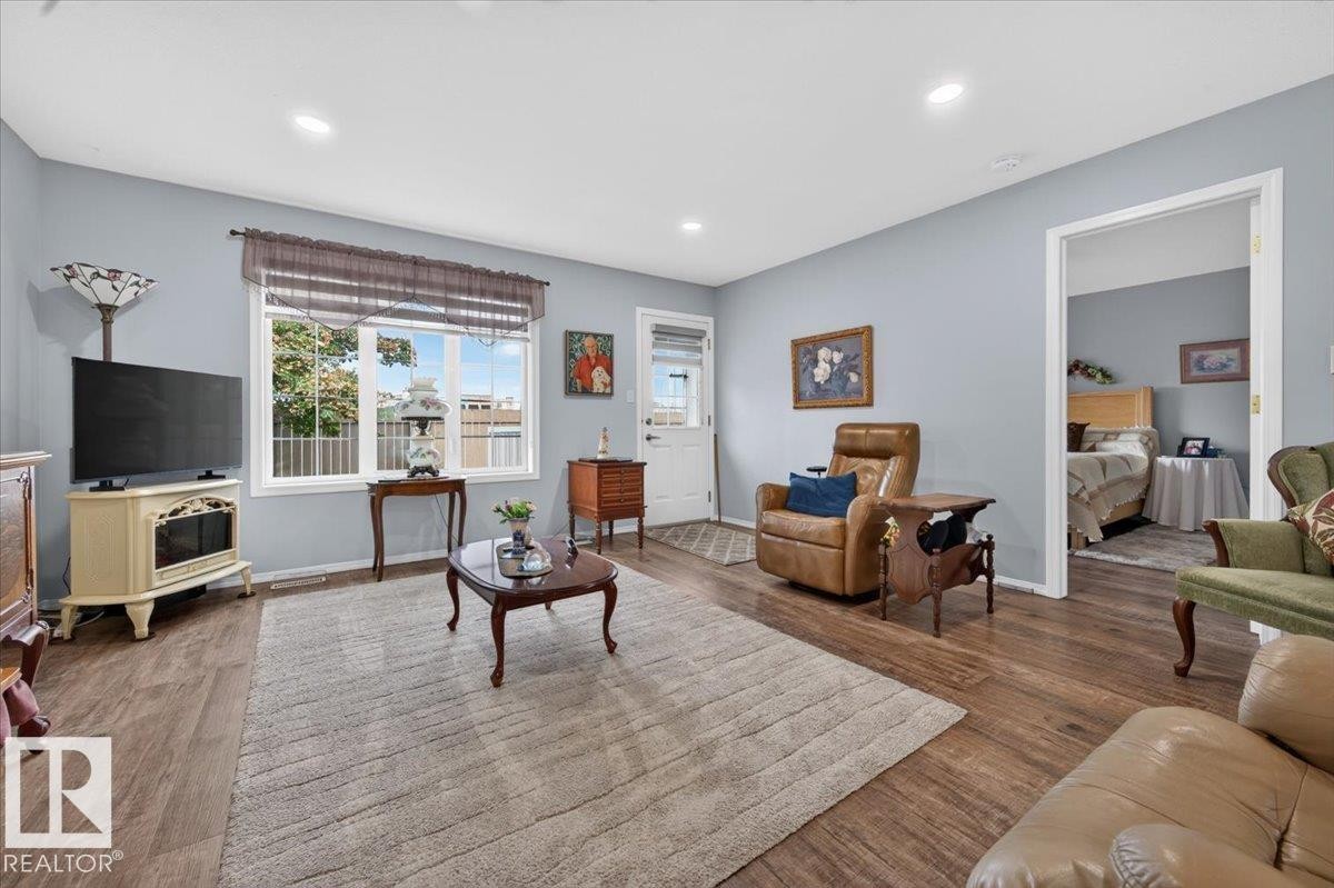 Hardwood-finish flooring throughout, recessed ceiling lighting, and a white-framed window - #125 4610 50 Ave, Stony Plain, AB