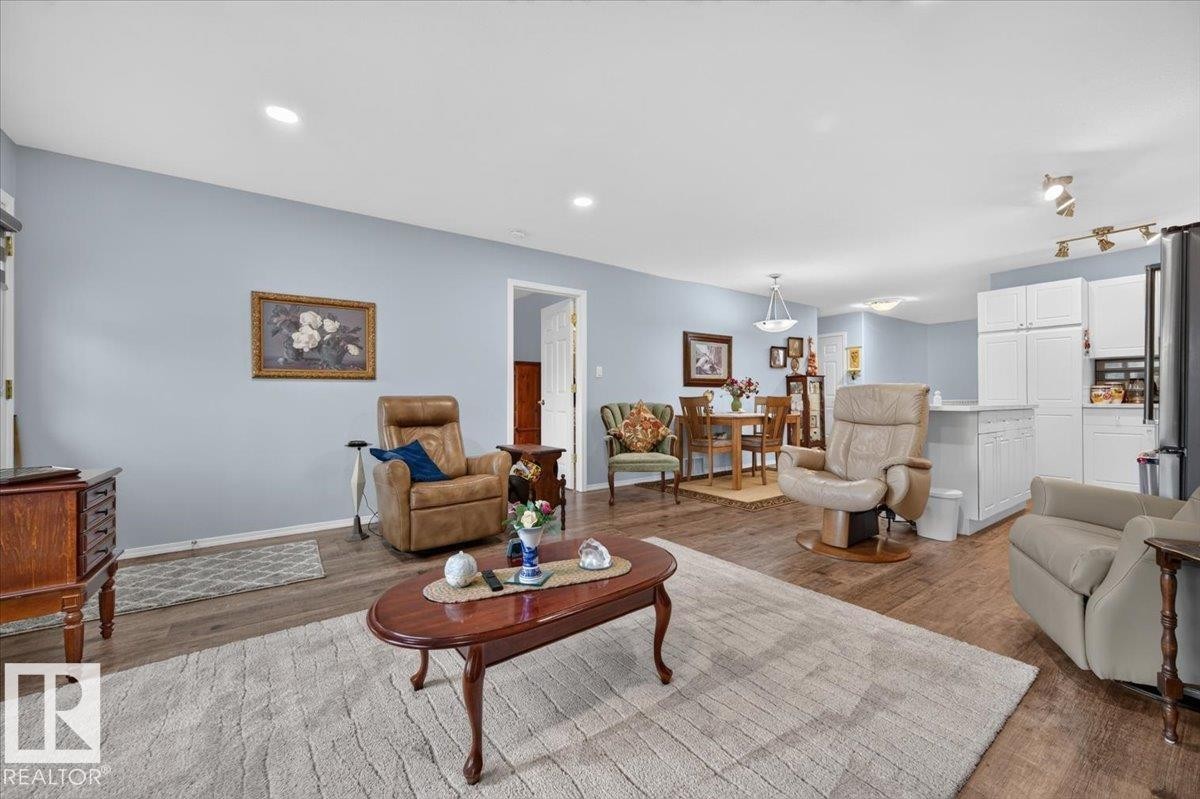 Recessed lighting, wood-finish flooring, white kitchen cabinetry, and track lighting - #125 4610 50 Ave, Stony Plain, AB