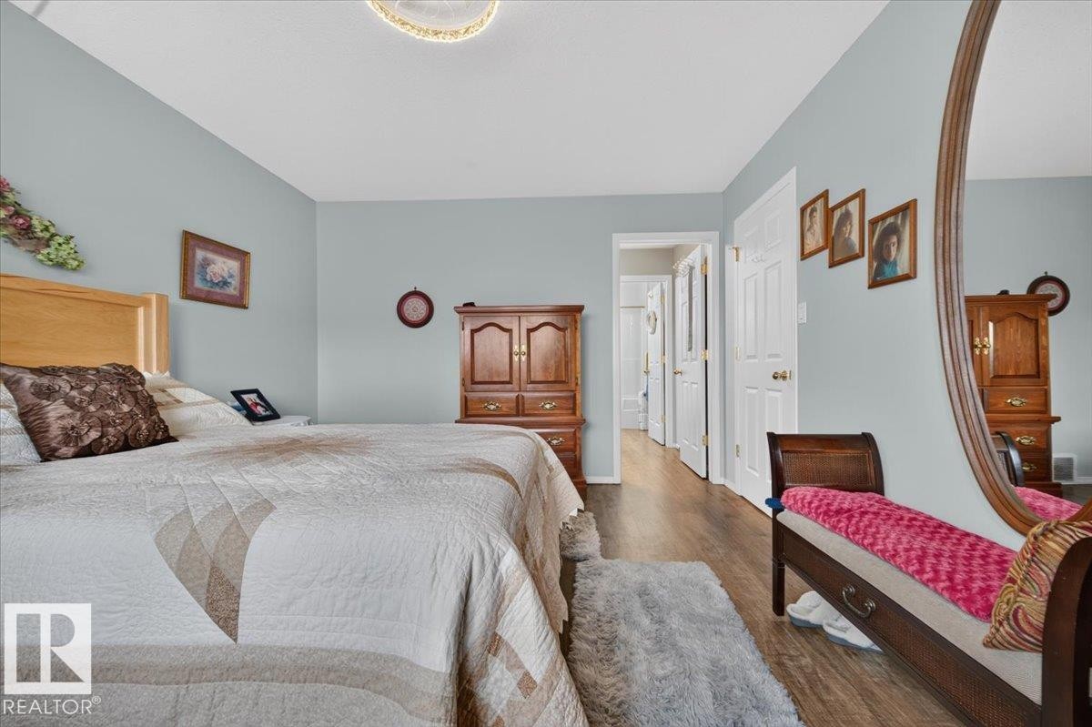 Wood-finish flooring throughout, light blue wall paint, and white trim - #125 4610 50 Ave, Stony Plain, AB