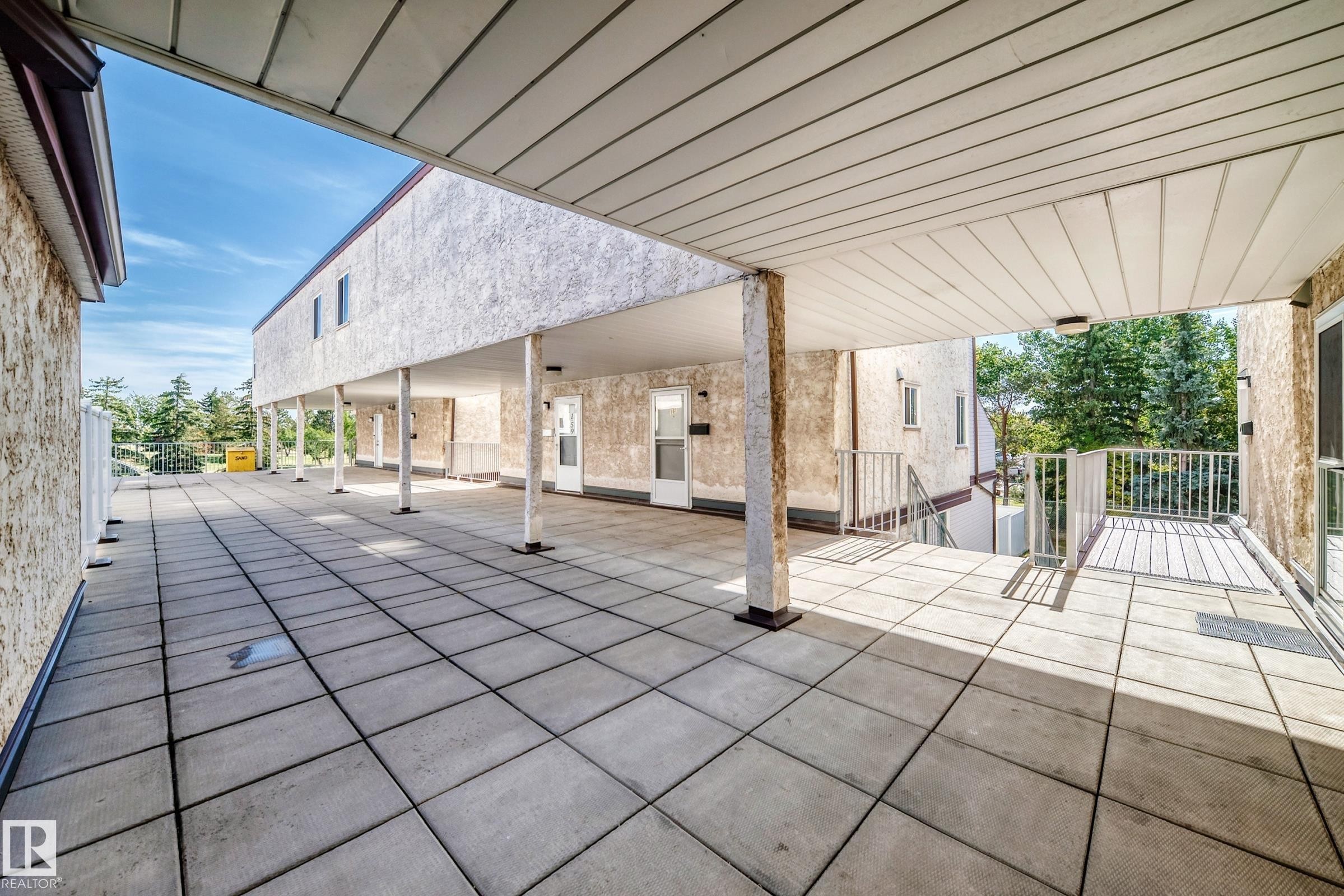 Expansive outdoor patio with concrete pavers and a covered walkway - 161 Lancaster Terrace Nw, Edmonton, AB