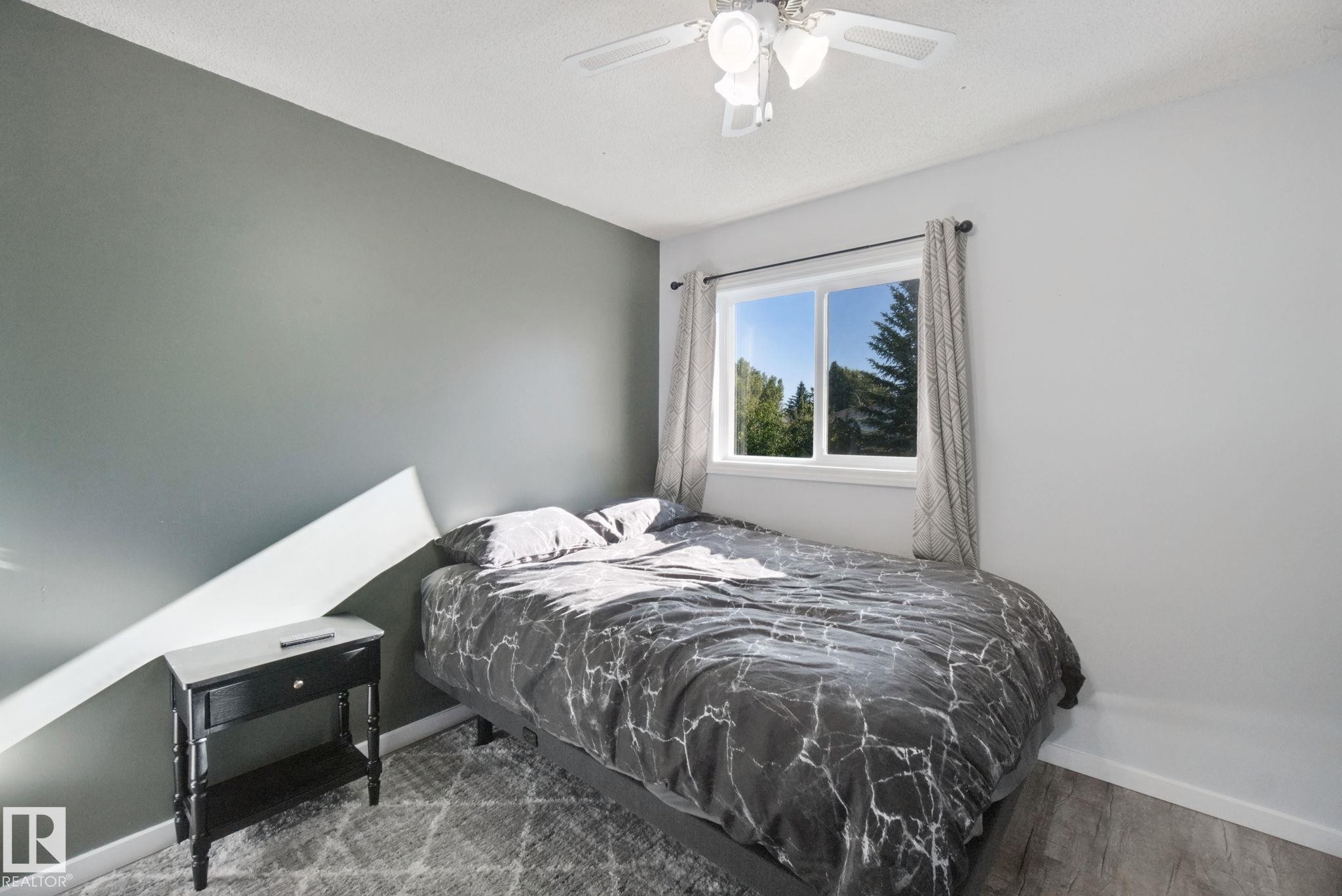 Single pane window, overhead ceiling fan with lighting, wood-finish flooring, two-tone wall treatment - 38 Menalta Place, Cardiff, AB
