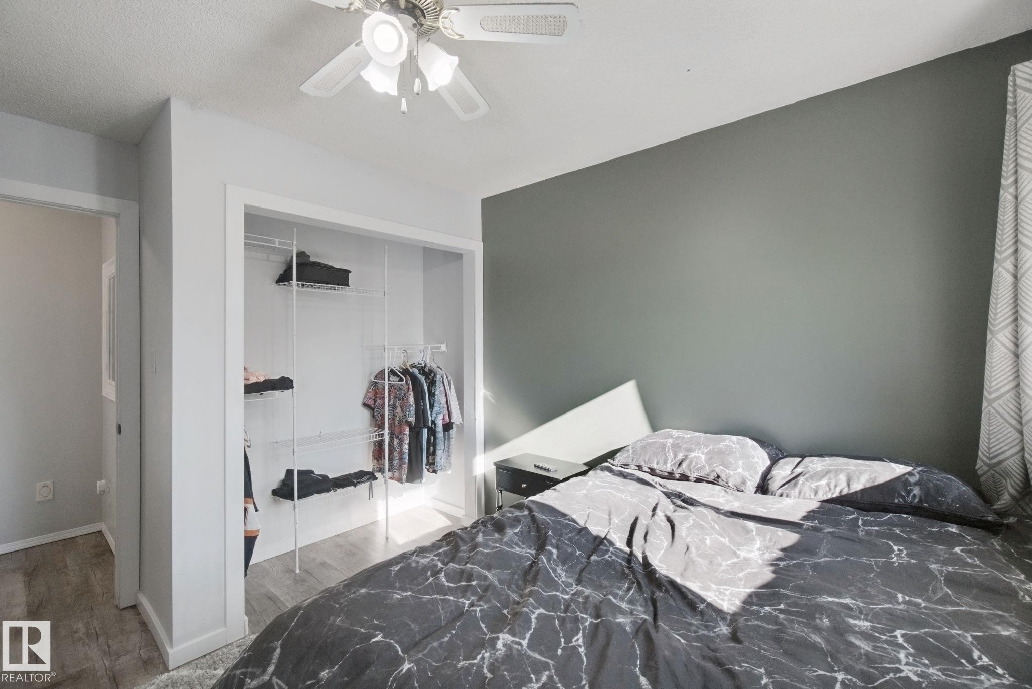 Recessed closet with built-in shelving, ceiling fan with light fixture, and wood-finish flooring - 38 Menalta Place, Cardiff, AB