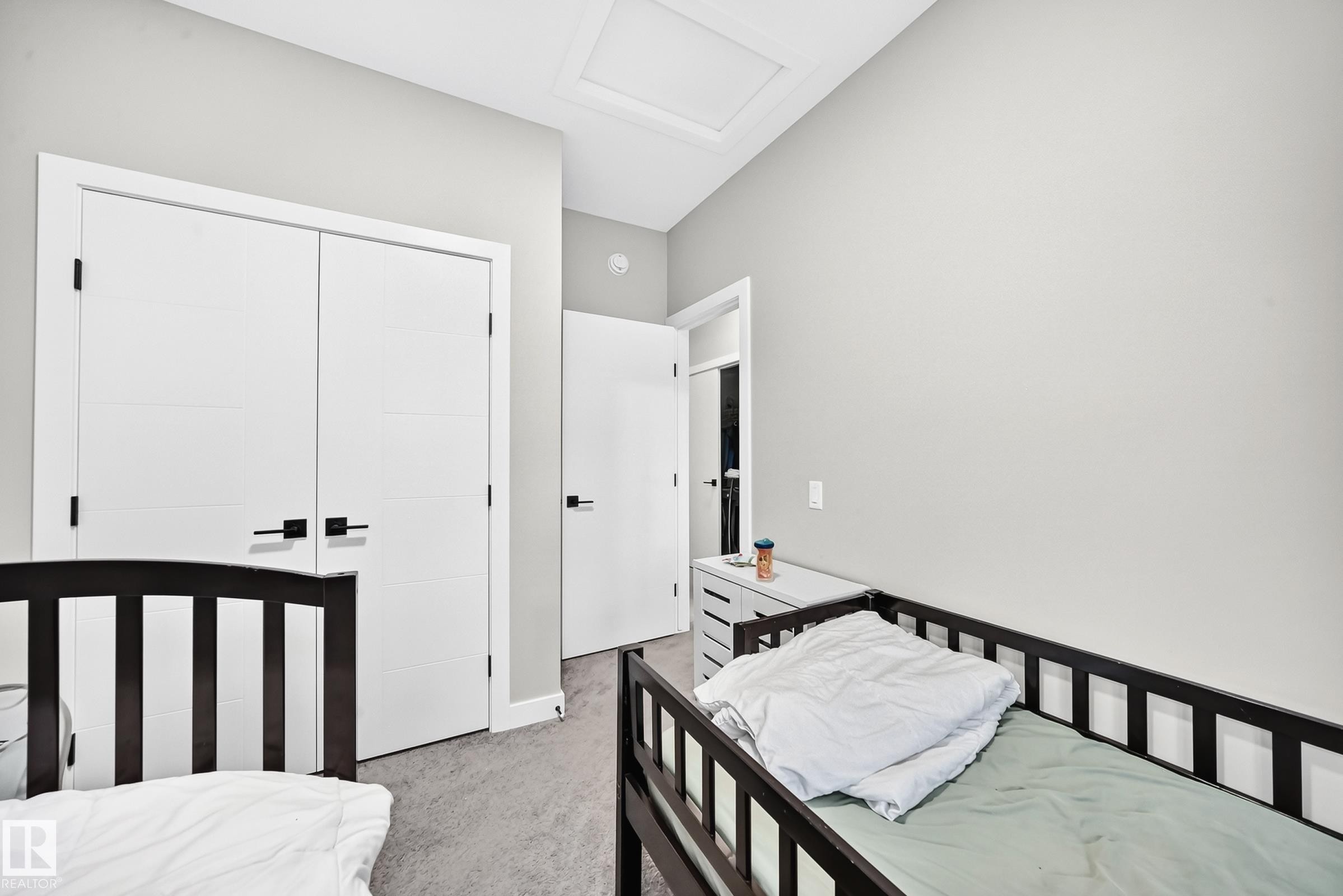 Vaulted ceiling, light gray wall paint, and double white doors with black hardware - 2415 194 Street Nw, Edmonton, AB
