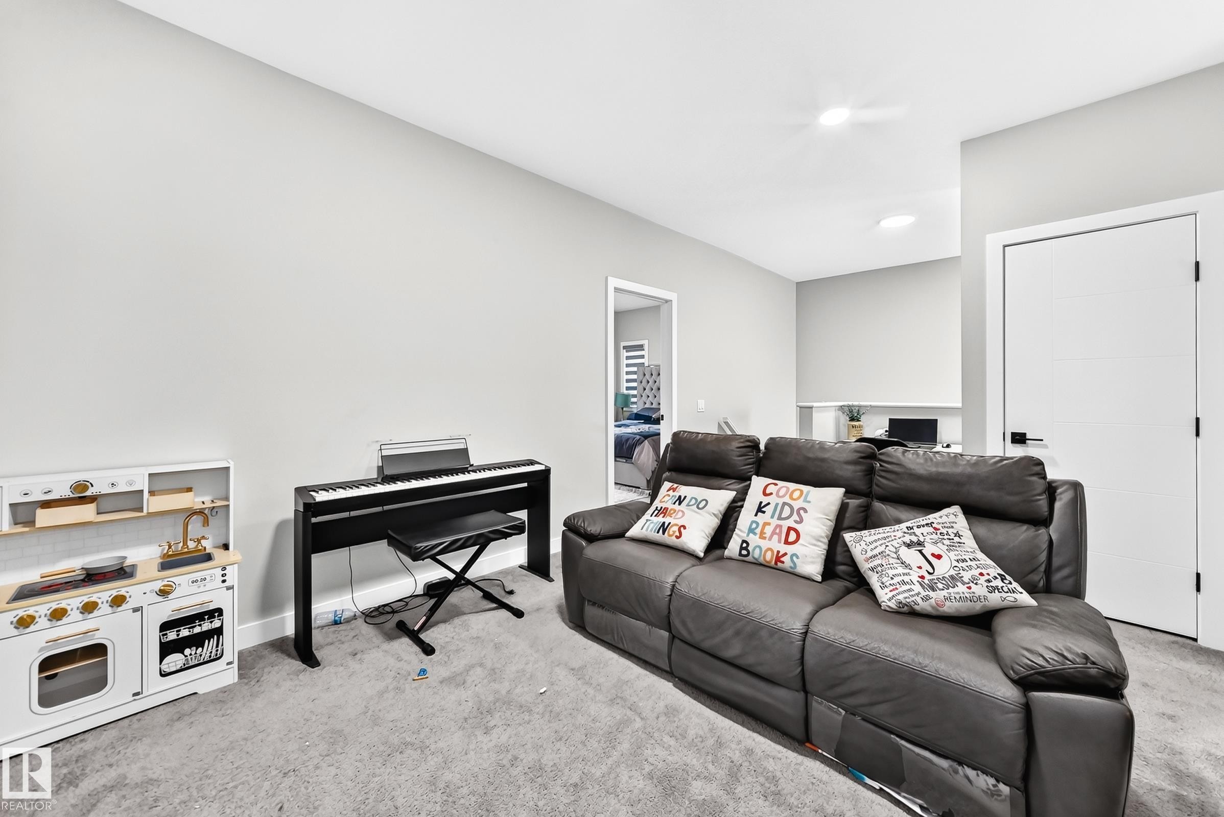 Recessed lighting illuminates neutral-toned walls and plush carpeting, enhancing the room's spacious feel - 2415 194 Street Nw, Edmonton, AB