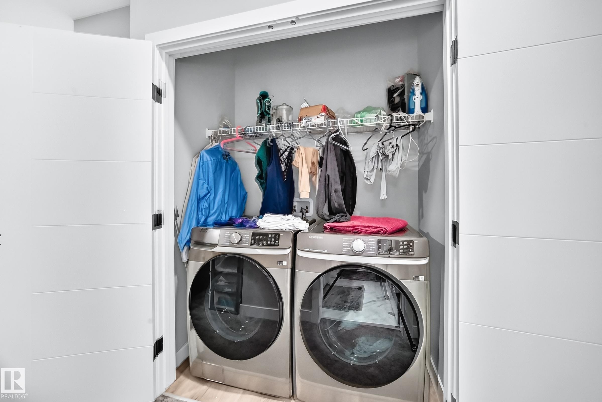 Laundry closet featuring a wire shelving system and dual modern doors with horizontal paneling - 2415 194 Street Nw, Edmonton, AB